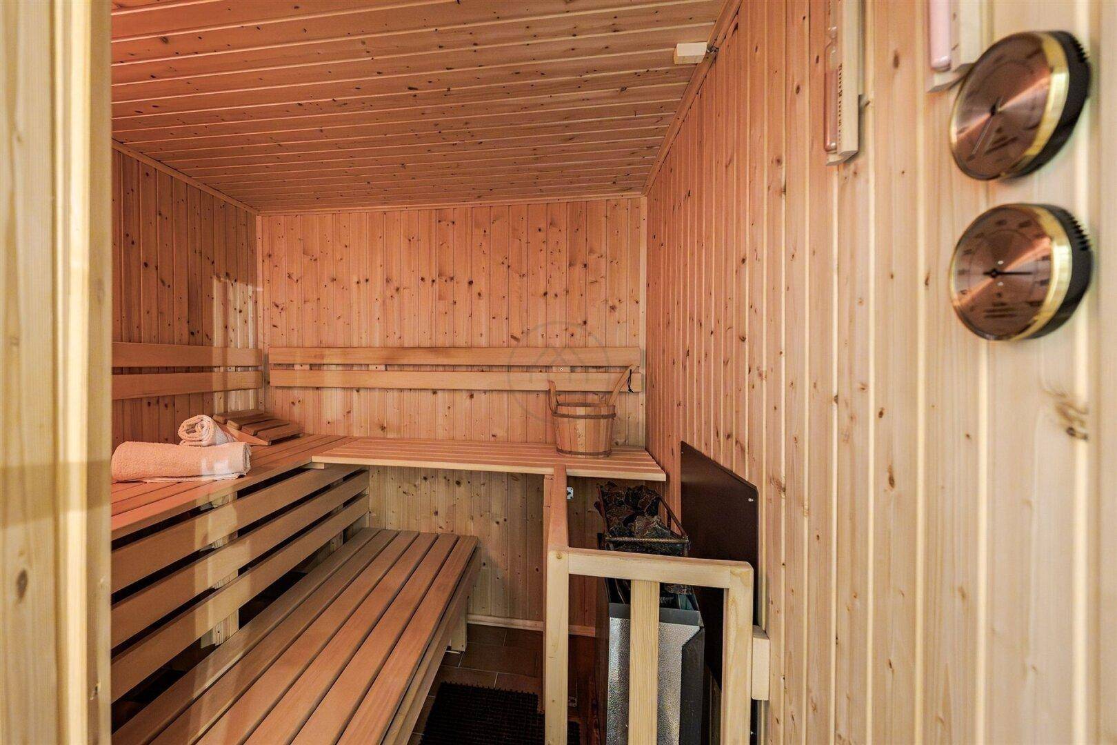 Gemütliche Holzsauna mit Bänken und Heizofen, perfekt für entspannende Momente im eigenen Zuhause.