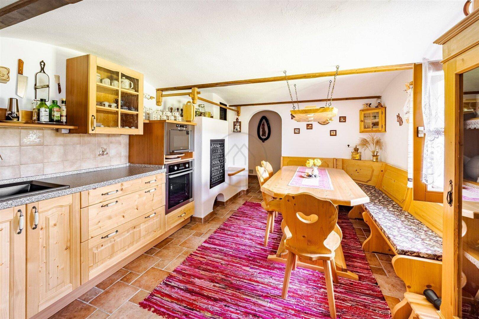 Helle Landhausküche mit Holzschränken, integrierten Geräten und einem gemütlichen Essbereich.