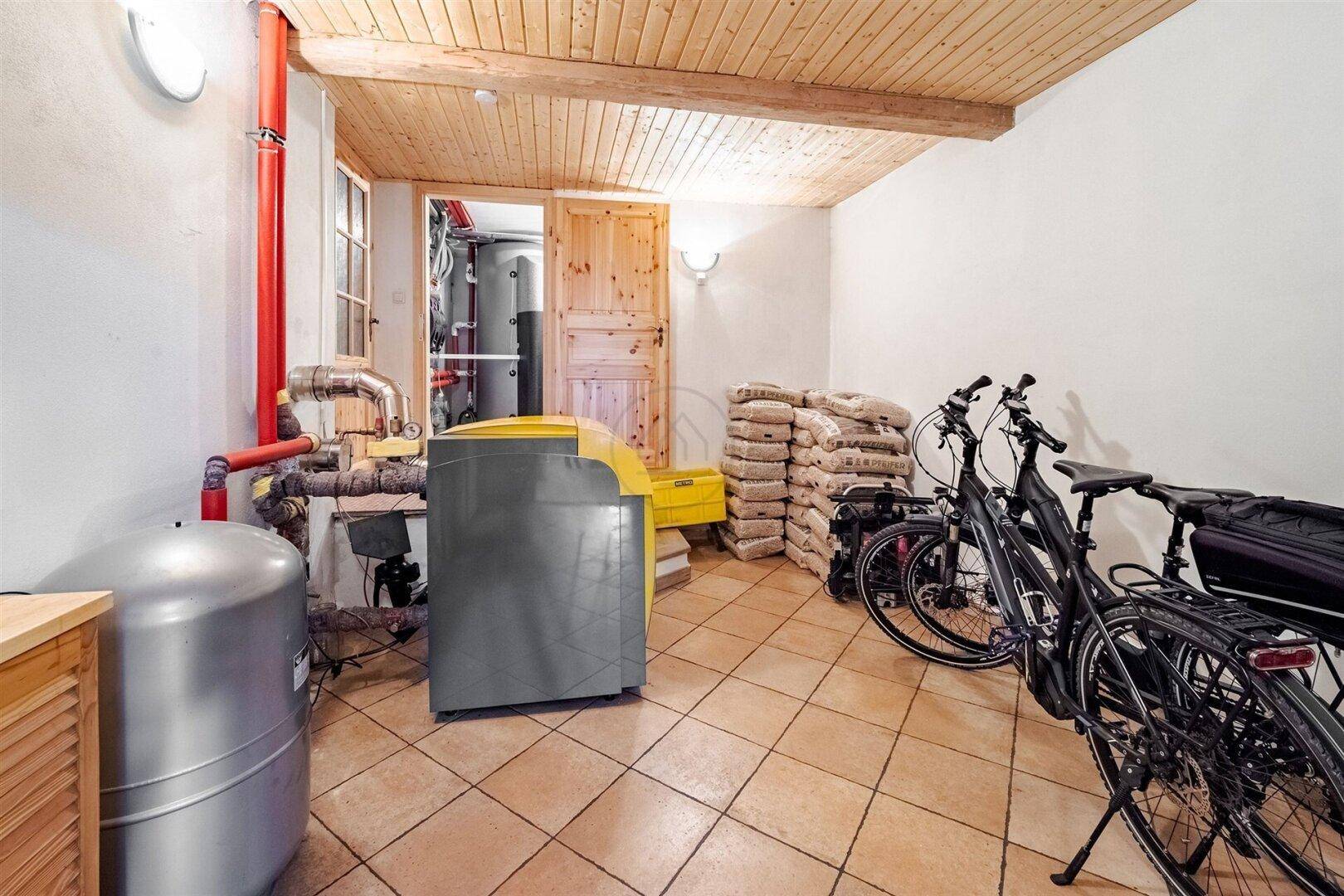 Heizungsraum im Keller mit Fahrrädern und Lagerflächen, ausgestattet mit einem Warmwasserspeicher.