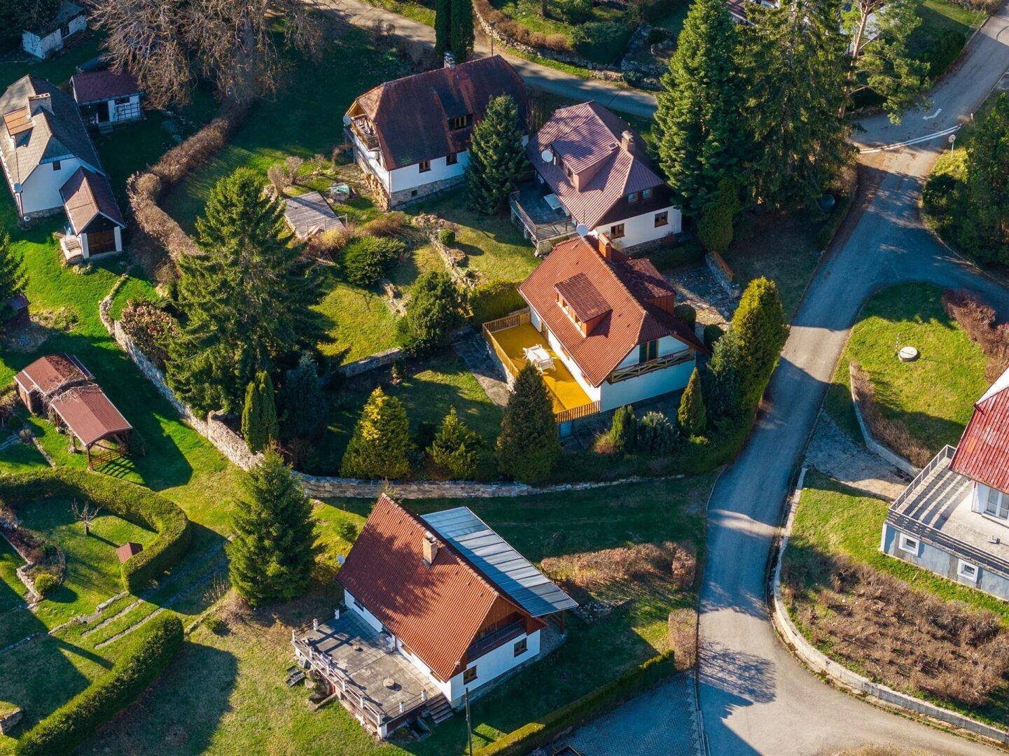 Vogelperspektive einer Wohnsiedlung mit mehreren Häusern und gepflegten Gärten.