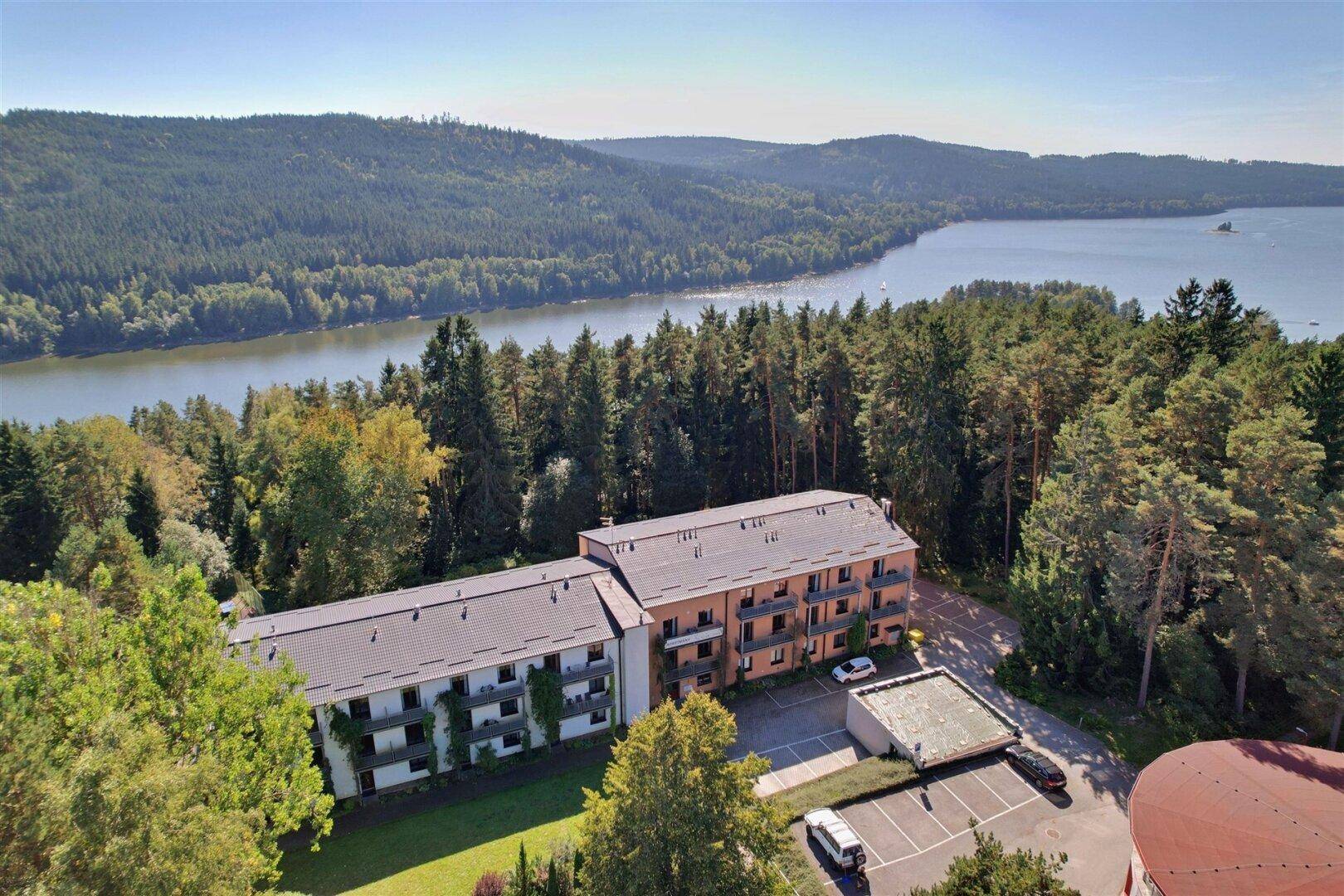 Weitläufige Luftaufnahme des Gebäudekomplexes in idyllischer Lage am Seeufer.
