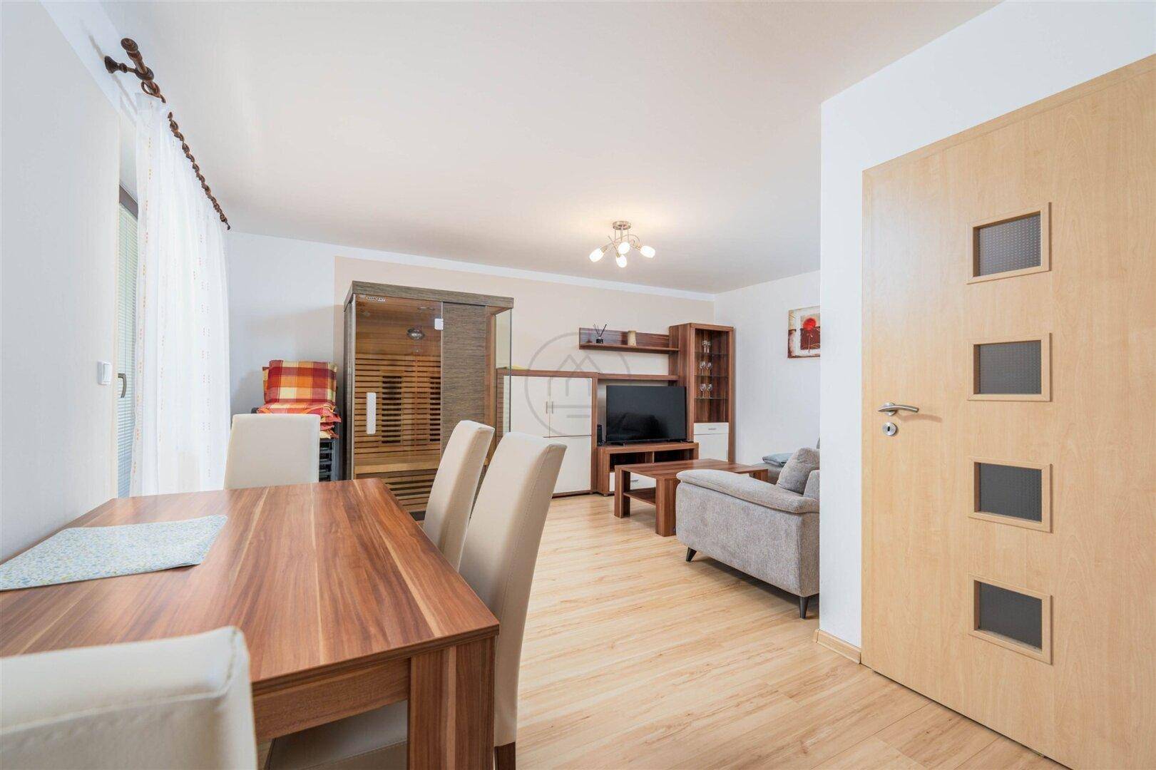 Gemütlicher Essbereich und Wohnzimmer mit Sofa, Holztisch und integrierter Sauna.