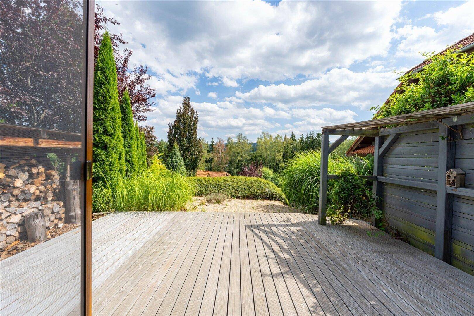 Große Holzterrasse mit weitem Blick ins Grüne und viel Platz für Entspannung im Freien.