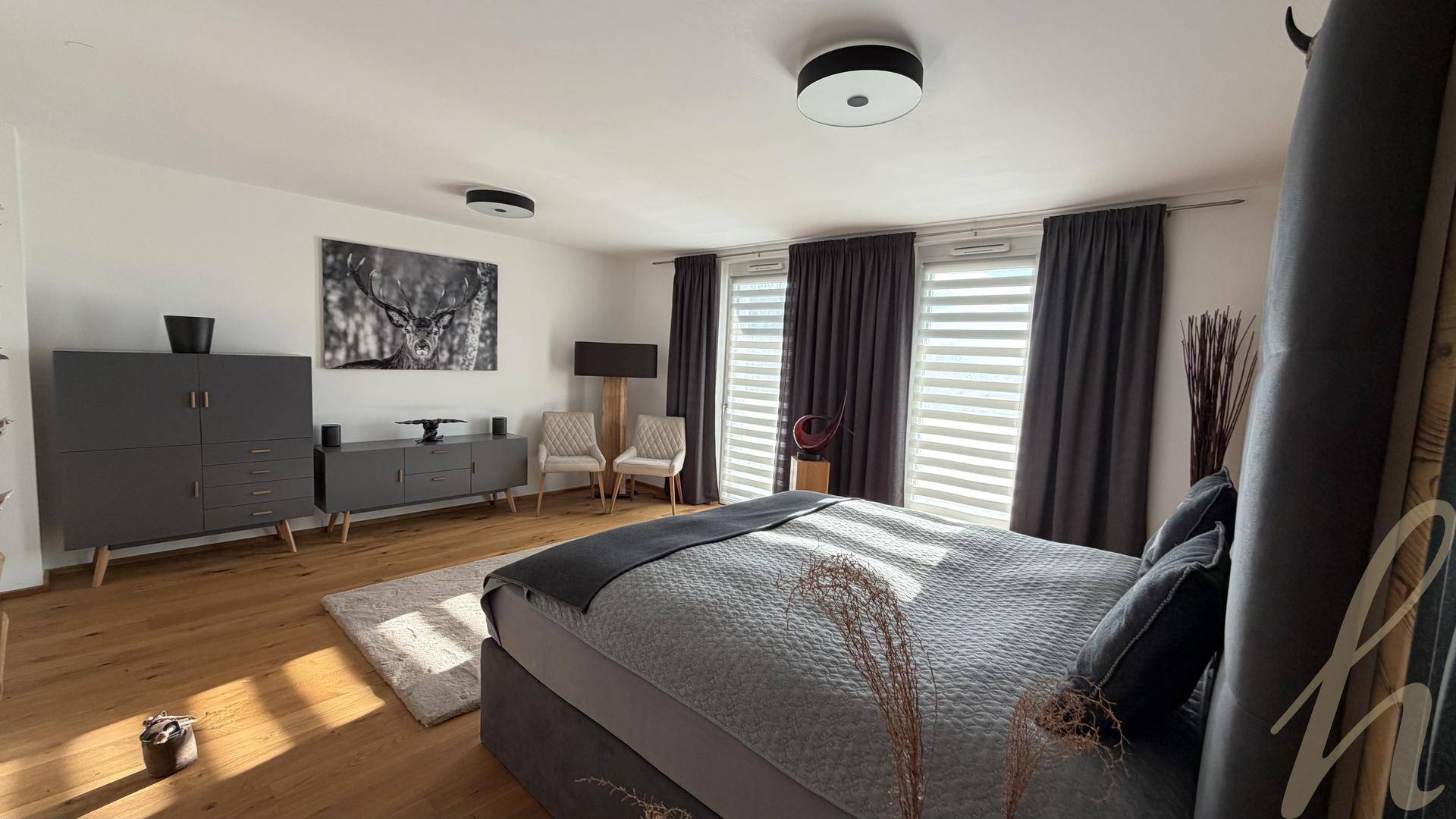 Geräumiges Schlafzimmer mit großem Bett, modernen Möbeln und Holzboden.