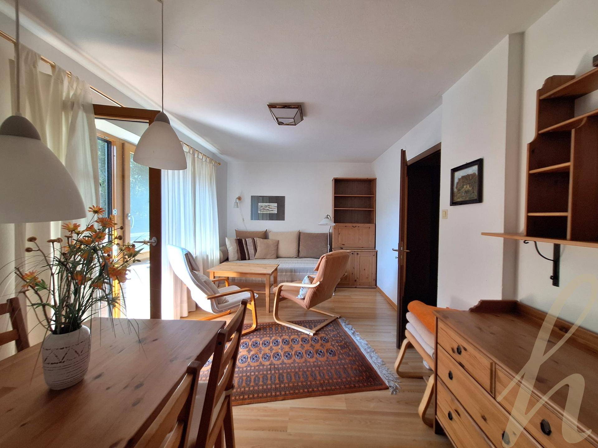 Geräumiger Wohn-Essbereich mit Holzboden, traditionellen Möbeln und einem Teppich.