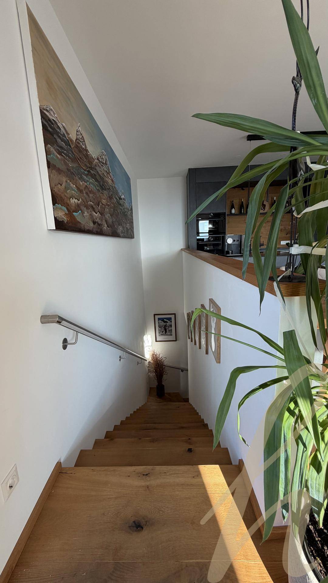 Blick von oben auf eine Holztreppe, die zu den unteren Etagen führt.