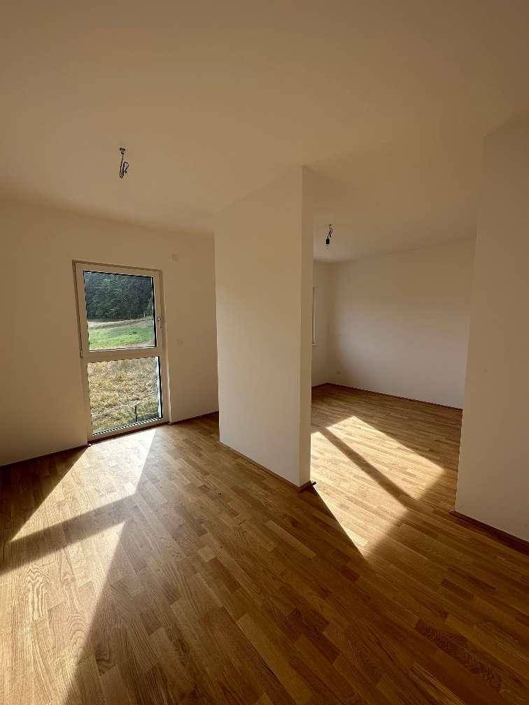 Helles Zimmer mit Holzboden und Zugang zum Garten, ideal als Schlaf- oder Arbeitszimmer.