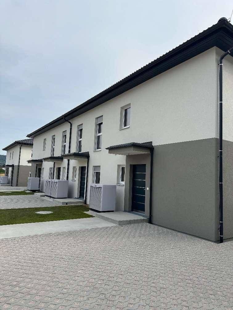 Detailansicht der Hauseingänge der Reihenhäuser mit modernen Türen und gepflastertem Zugang.