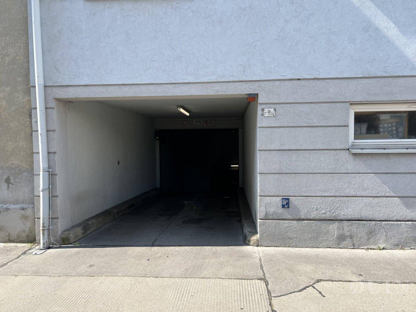 Eingang zur Tiefgarage eines Wohngebäudes mit einfacher Fassade.