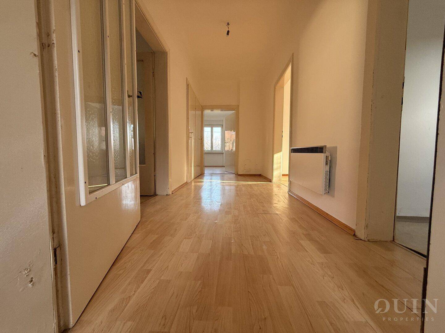 Heller Flur mit Laminatboden, der zu verschiedenen Räumen im Haus führt.