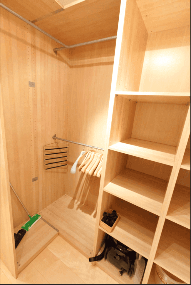 Praktischer begehbarer Kleiderschrank mit Holzregalen und Kleiderstangen für effizienten Stauraum.