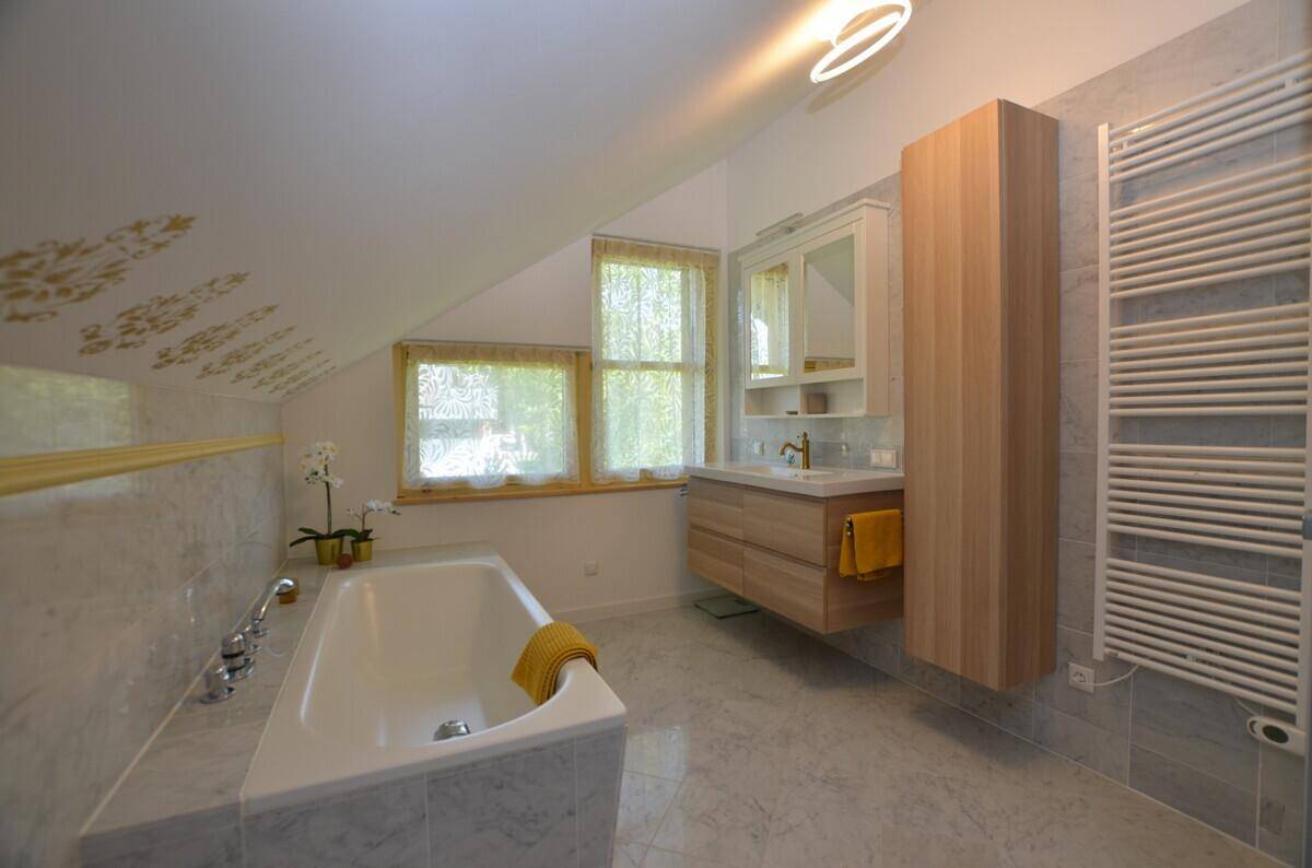 Modernes Badezimmer mit Badewanne, schwebendem Waschtisch und beheiztem Handtuchhalter.