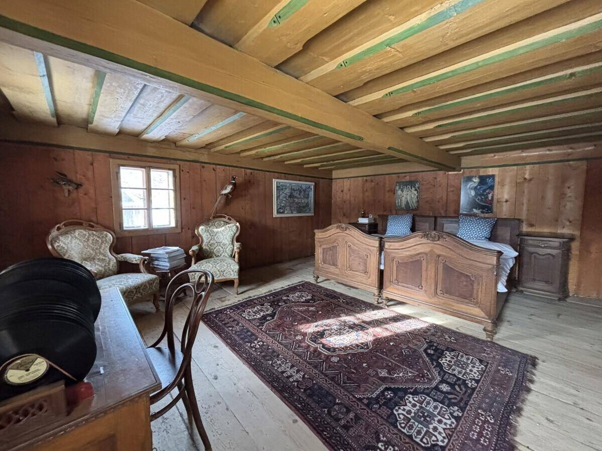 Helles Schlafzimmer mit zwei Einzelbetten, Holzboden und rustikalen Holzmöbeln.