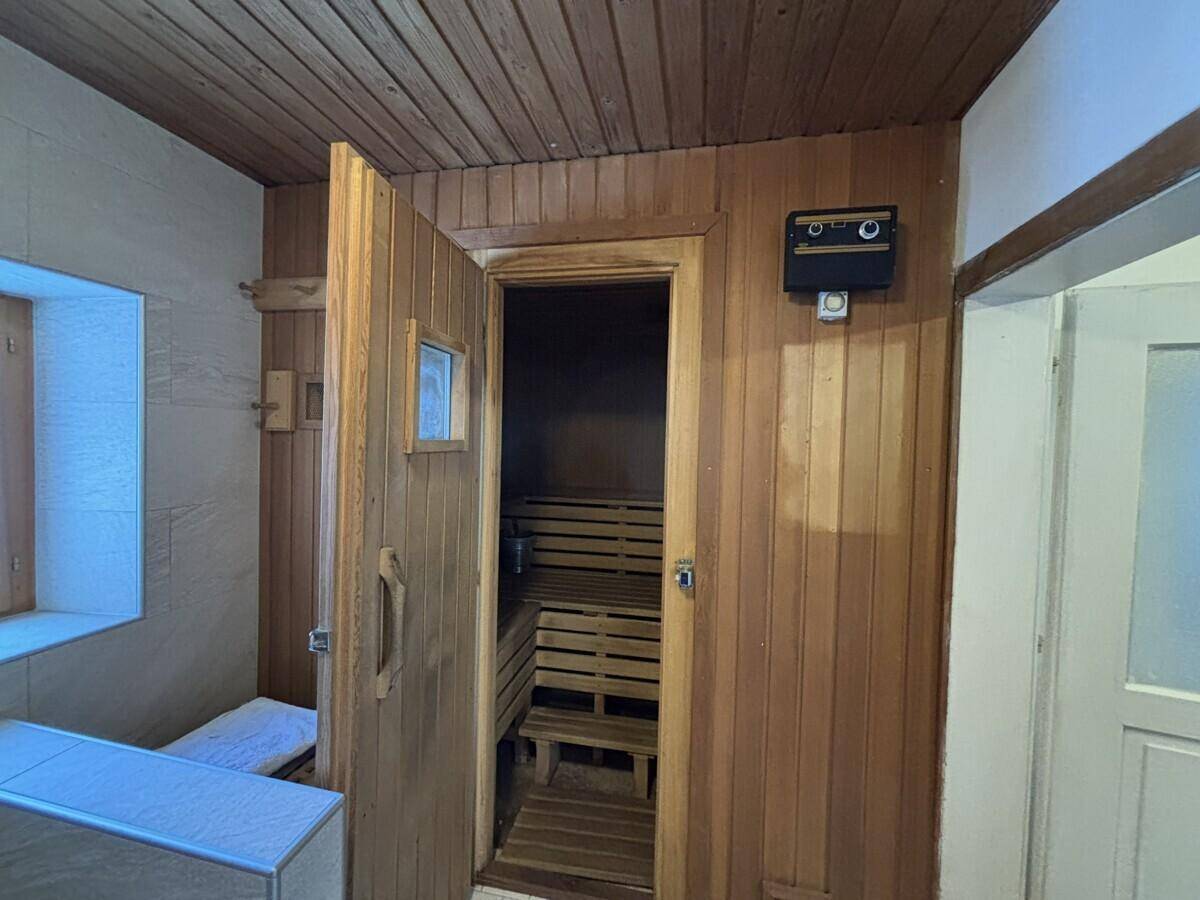 Badezimmer mit integrierter Holzsauna, die zum Entspannen einlädt.