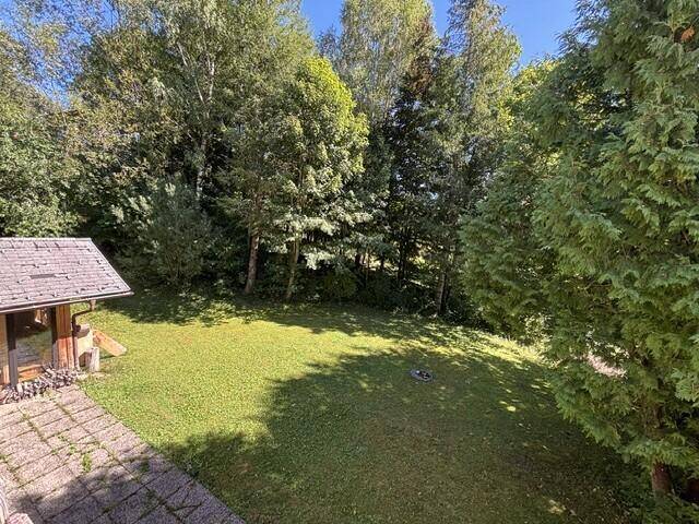 Weitläufiger, gepflegter Gartenbereich mit Rasen und altem Baumbestand, ideal zum Entspannen.