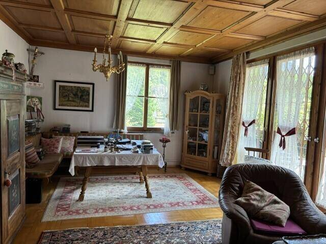 Gemütliches Wohnzimmer mit Holzkassettendecke, Parkettboden und traditionellen Möbeln.