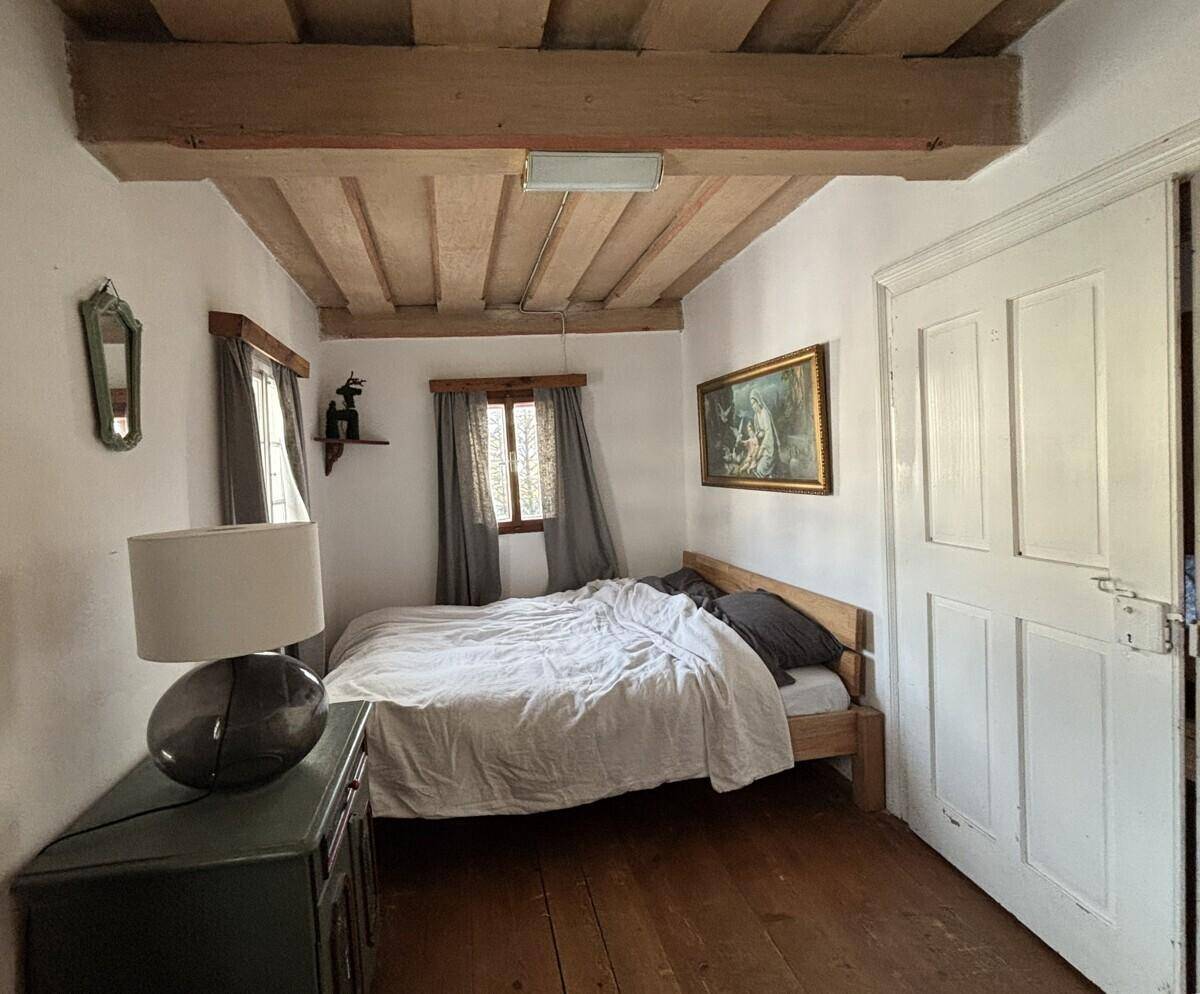 Gemütliches Schlafzimmer mit Einzelbett, Holzboden und einem Fenster.