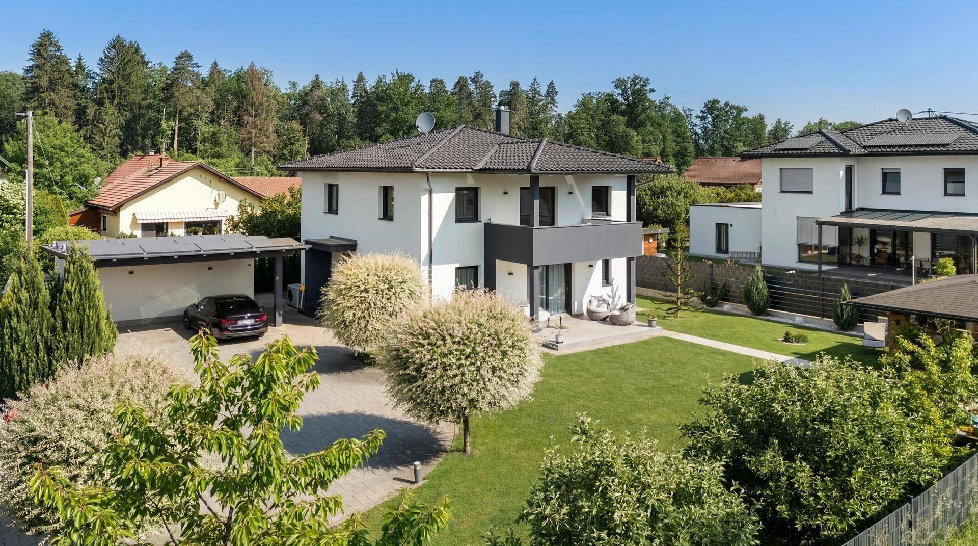 Modernes Einfamilienhaus mit gepflegtem Garten, Carport und sonniger Auffahrt.