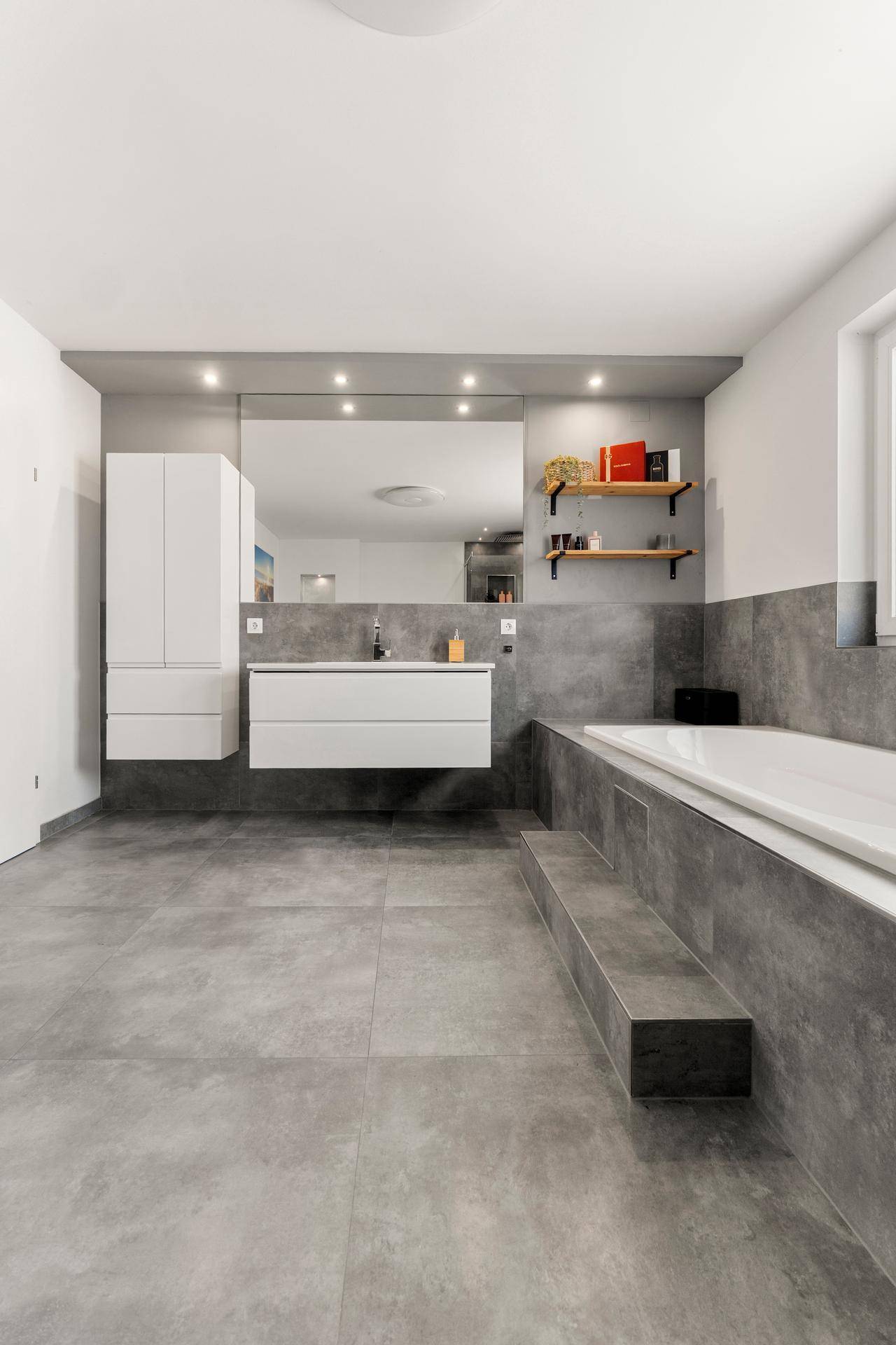 Elegantes Badezimmer mit Doppelwaschbecken, großer Spiegelfläche und integrierter Badewanne.