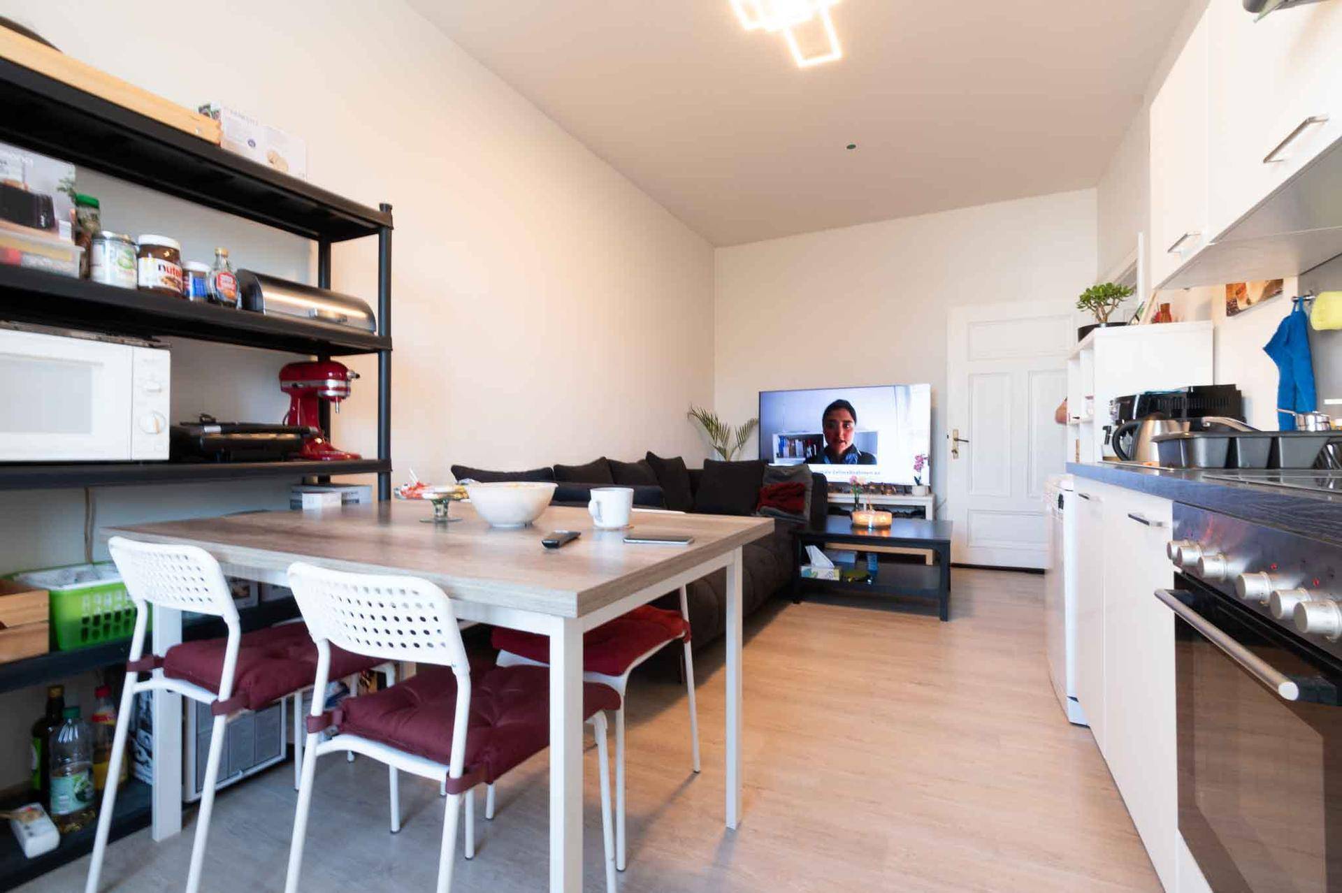 Geräumiger Wohnbereich mit Esstisch, Sofa und offener Küche, ideal für geselliges Beisammensein.