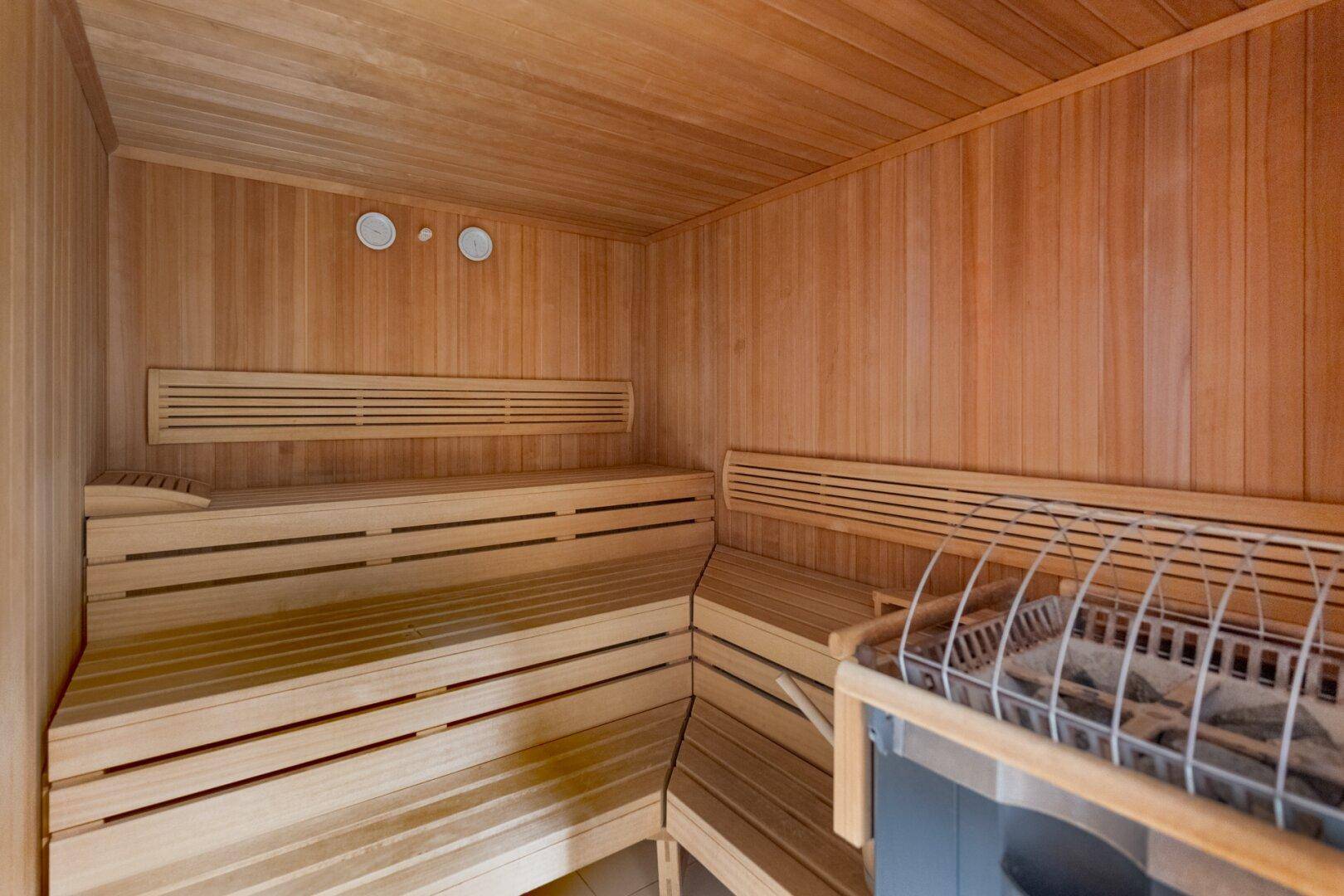 Traditionelle Holzsauna mit mehreren Bänken und einem Saunaofen für Entspannung.