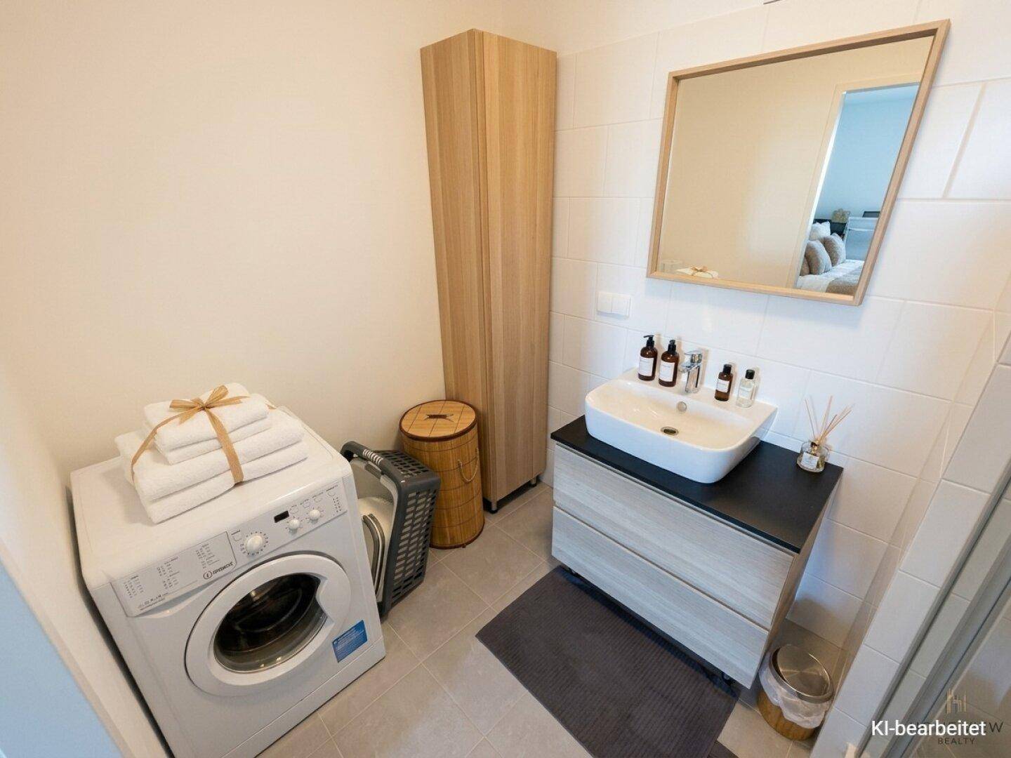 Modernes Badezimmer mit Waschmaschine, Waschtisch und großem Spiegel.