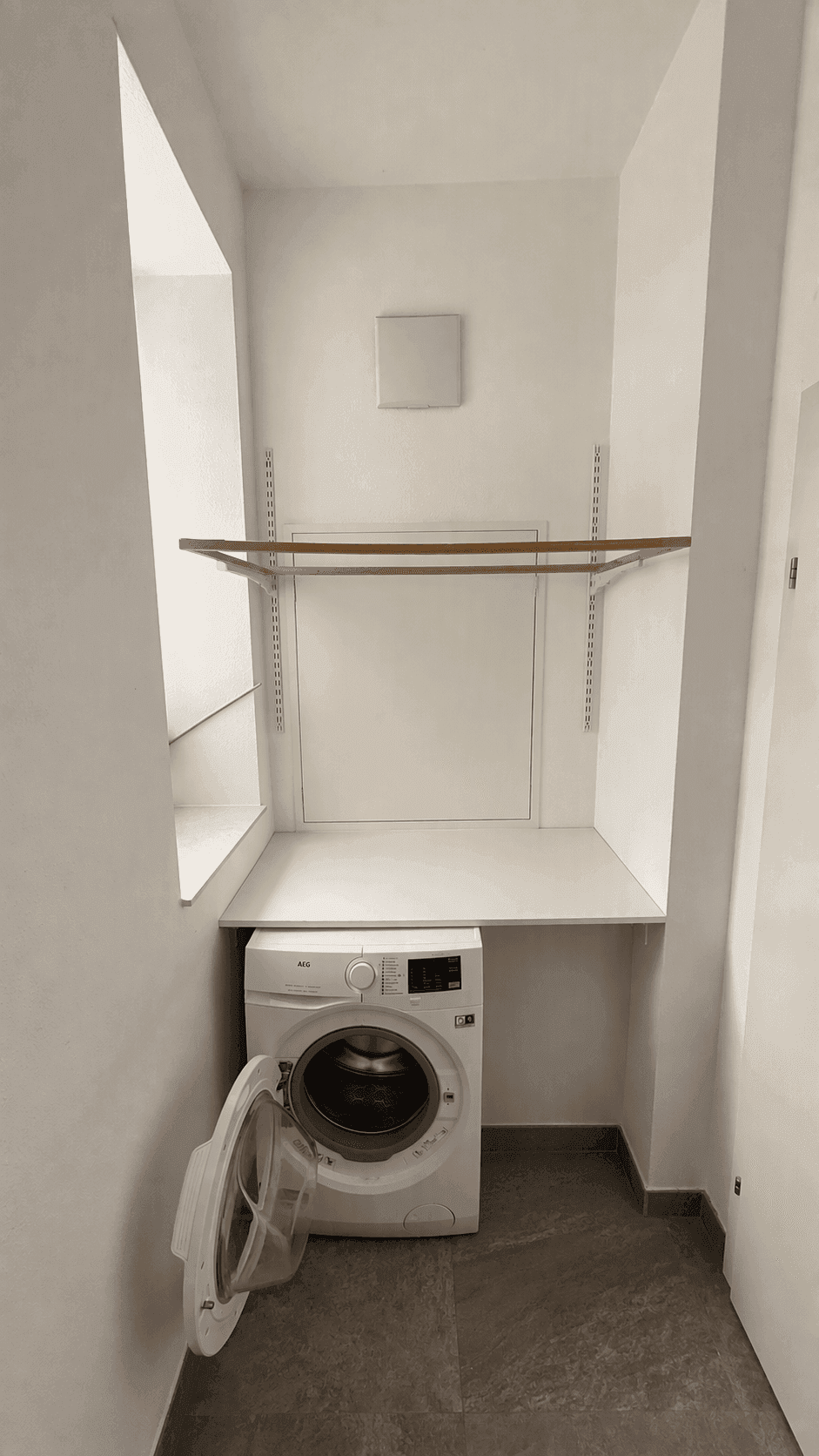 Praktischer Hauswirtschaftsraum mit Waschmaschine und Ablageflächen.