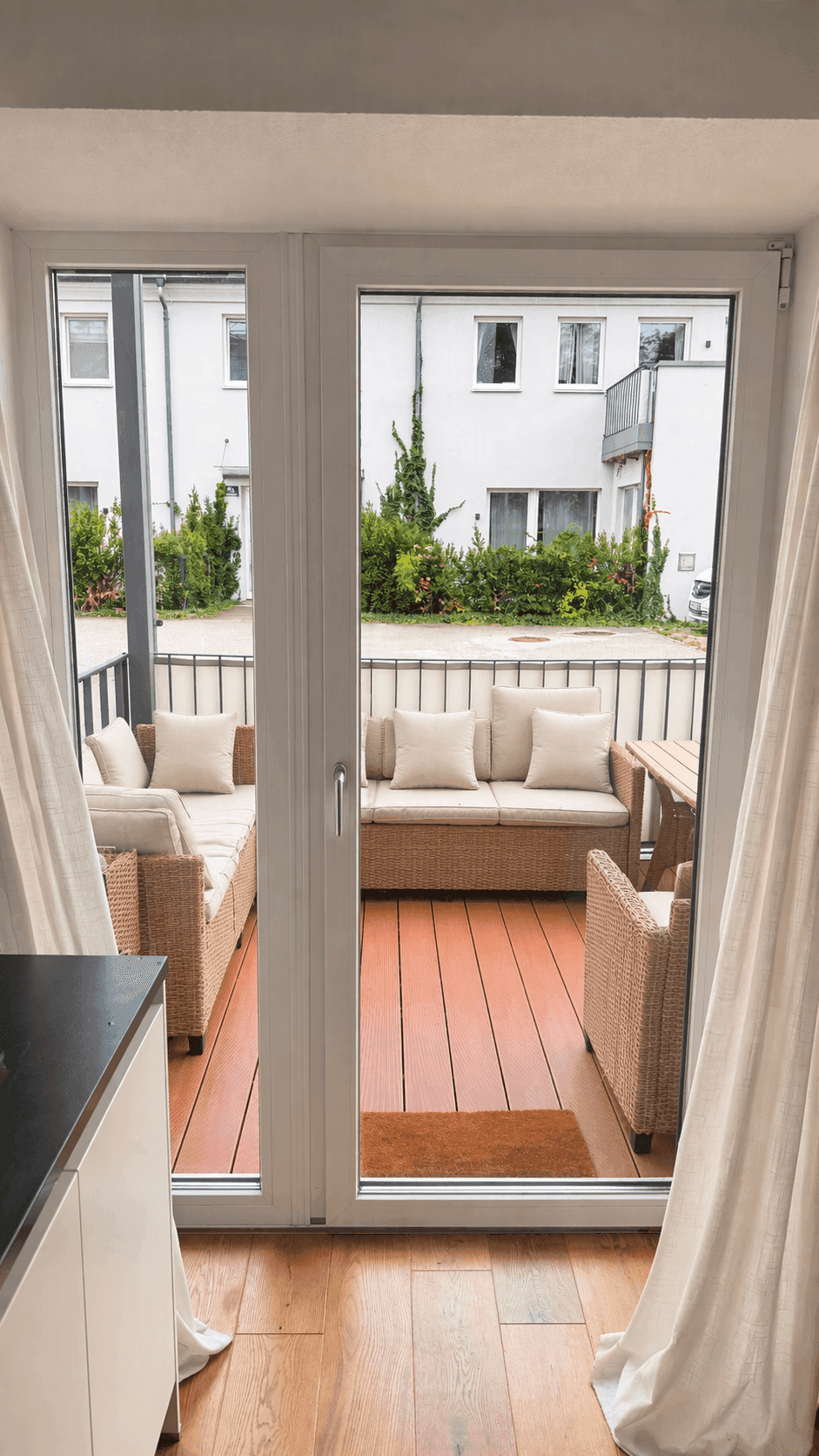 Möblierte Terrasse mit Rattanmöbeln und Blick auf die umliegenden Gebäude.