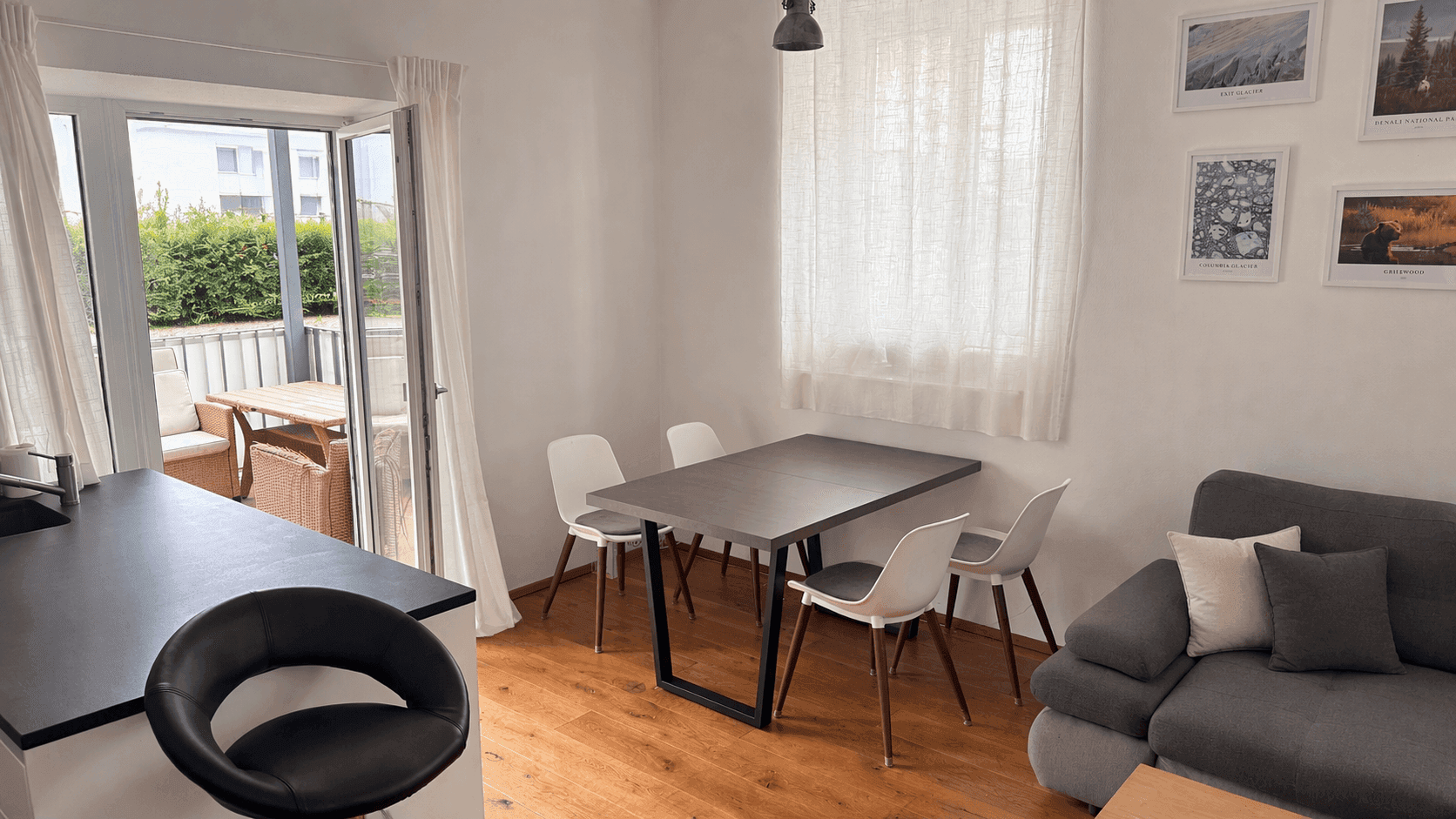 Offener Wohn-Essbereich mit Esstisch, Sofa und Zugang zur Terrasse.