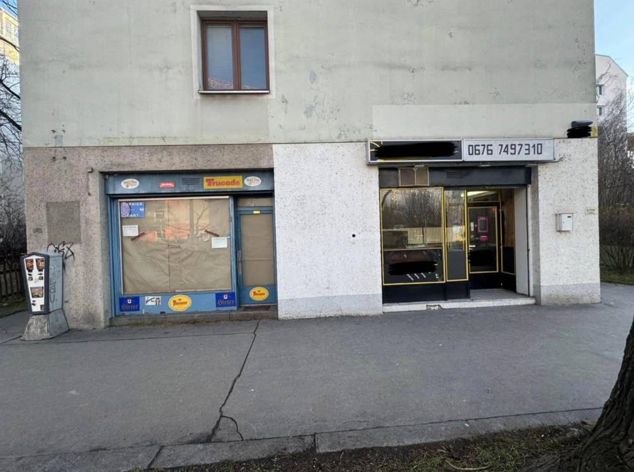 Außenansicht eines Gebäudes mit zwei Ladenlokalen im Erdgeschoss und einer oberen Etage.