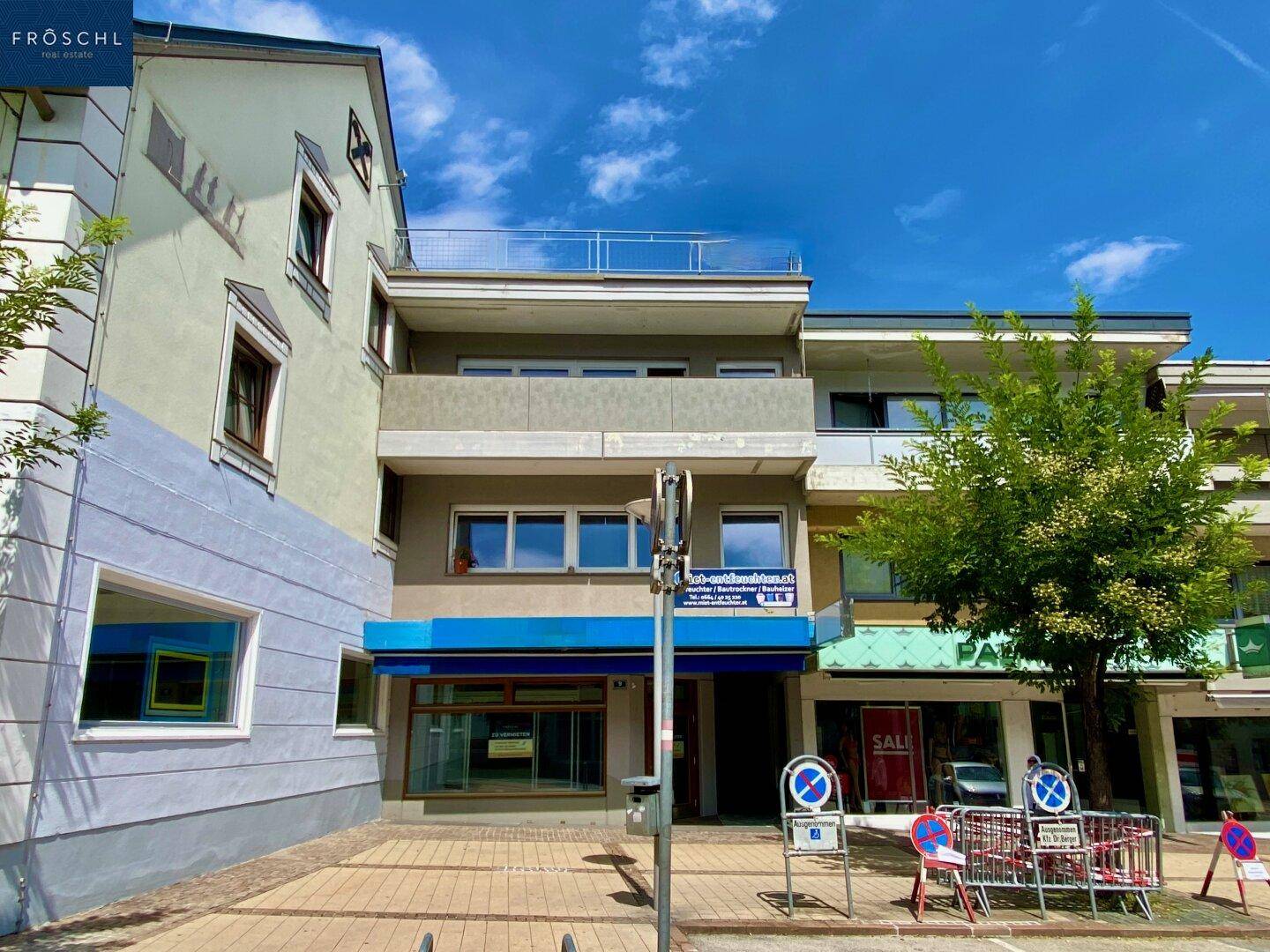 Mehrstöckiges Geschäftsgebäude mit Balkonen, großen Fenstern und einer modernen Fassade.