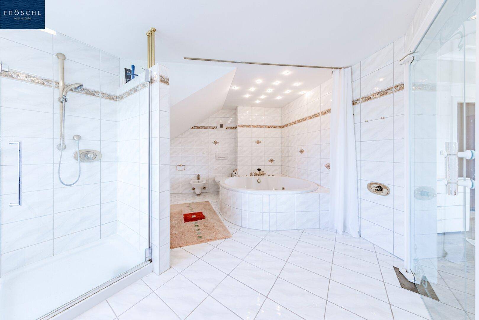 Helles Badezimmer mit Dusche, Eckbadewanne, Bidet und weißen Fliesen.