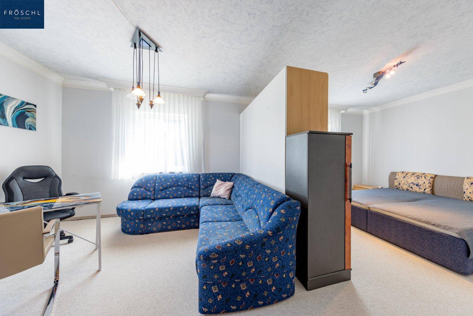 Vielseitiges Zimmer mit Sofa, Schreibtisch und Bett, ideal als Gäste- oder Arbeitszimmer.
