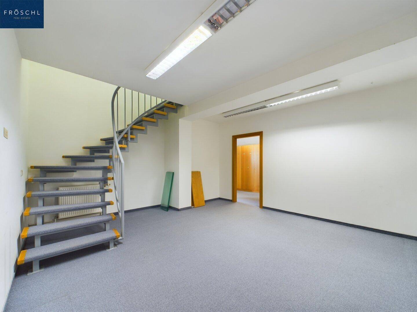 Raum mit einer eleganten Wendeltreppe und Teppichboden, der zu weiteren Etagen führt.