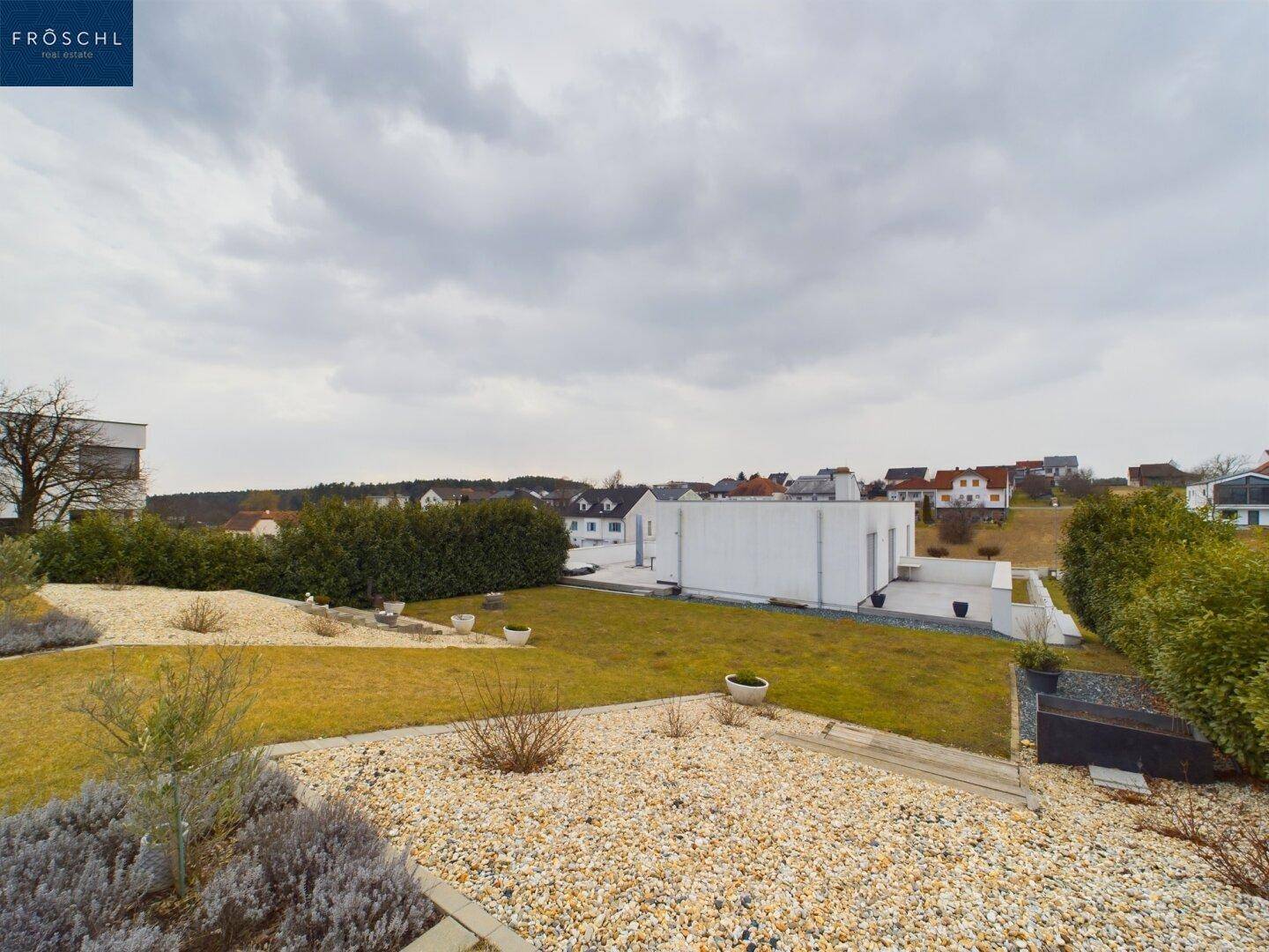 Panoramablick über den Garten und die umliegende Wohnsiedlung mit viel Grün.