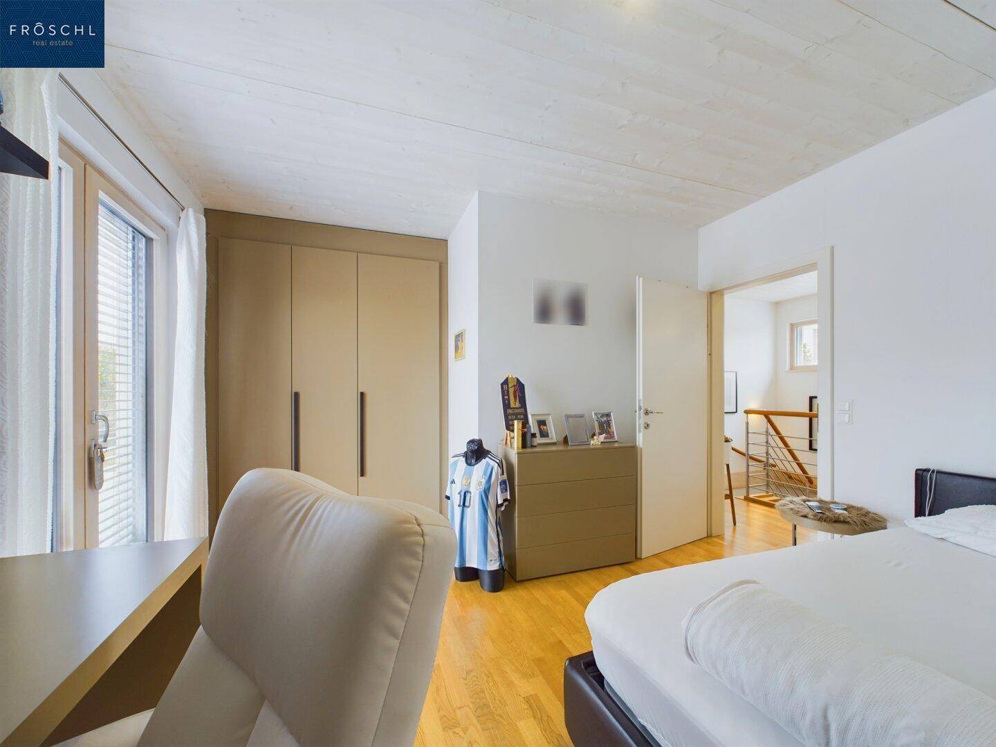 Helles Schlafzimmer mit Einbauschränken und Zugang zu einem Balkon oder einer Terrasse.