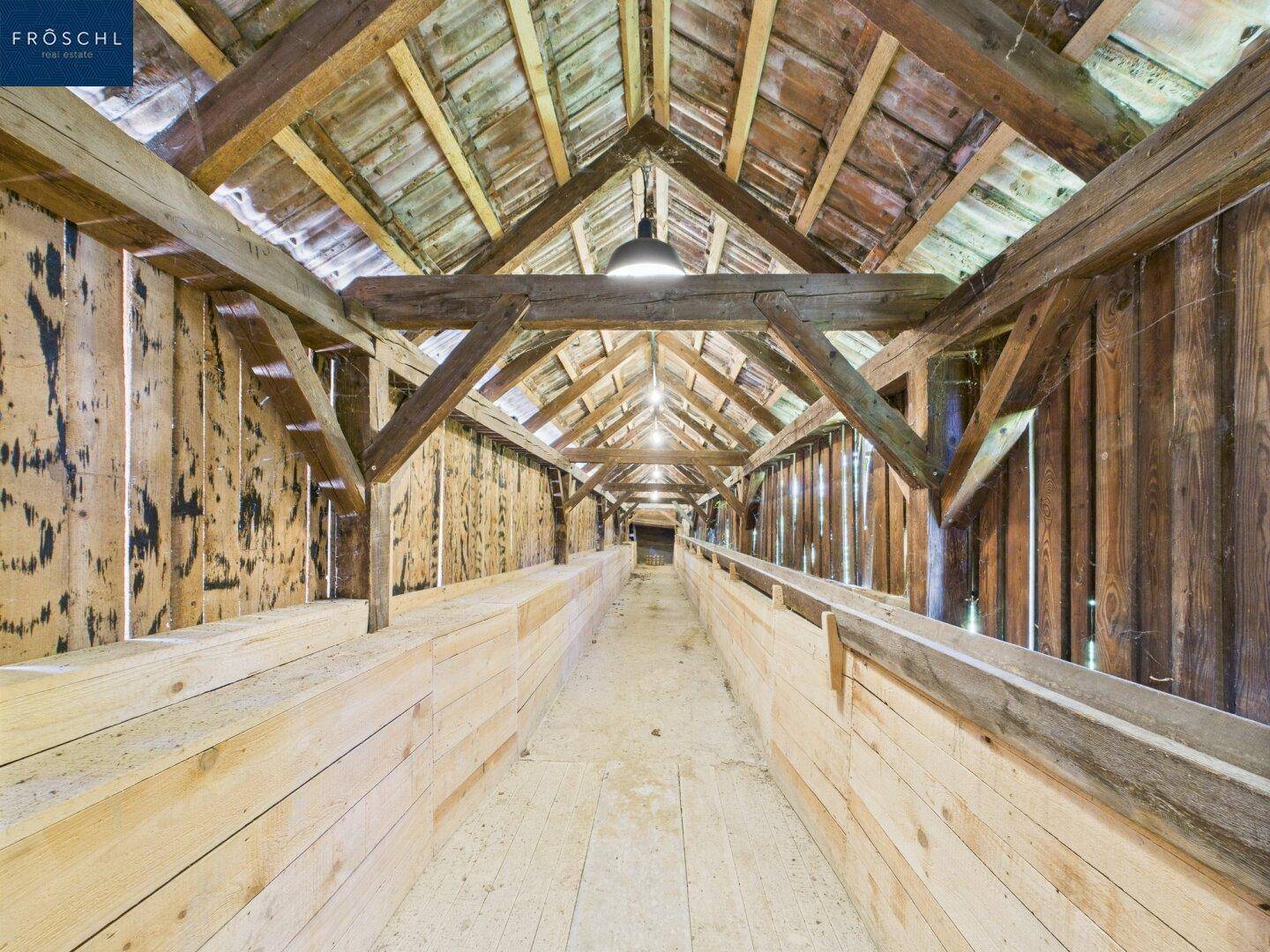 Langer Dachboden mit Holzbalken und Holzverkleidung, bietet viel Stauraum.