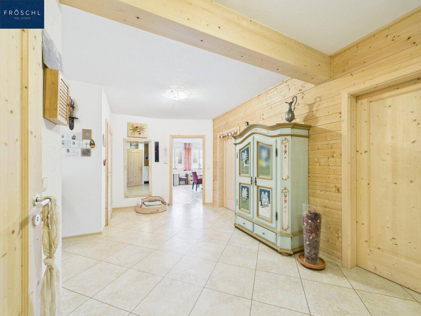 Heller Flur mit Holzvertäfelung, gefliestem Boden und traditionellem Schrank als Blickfang.