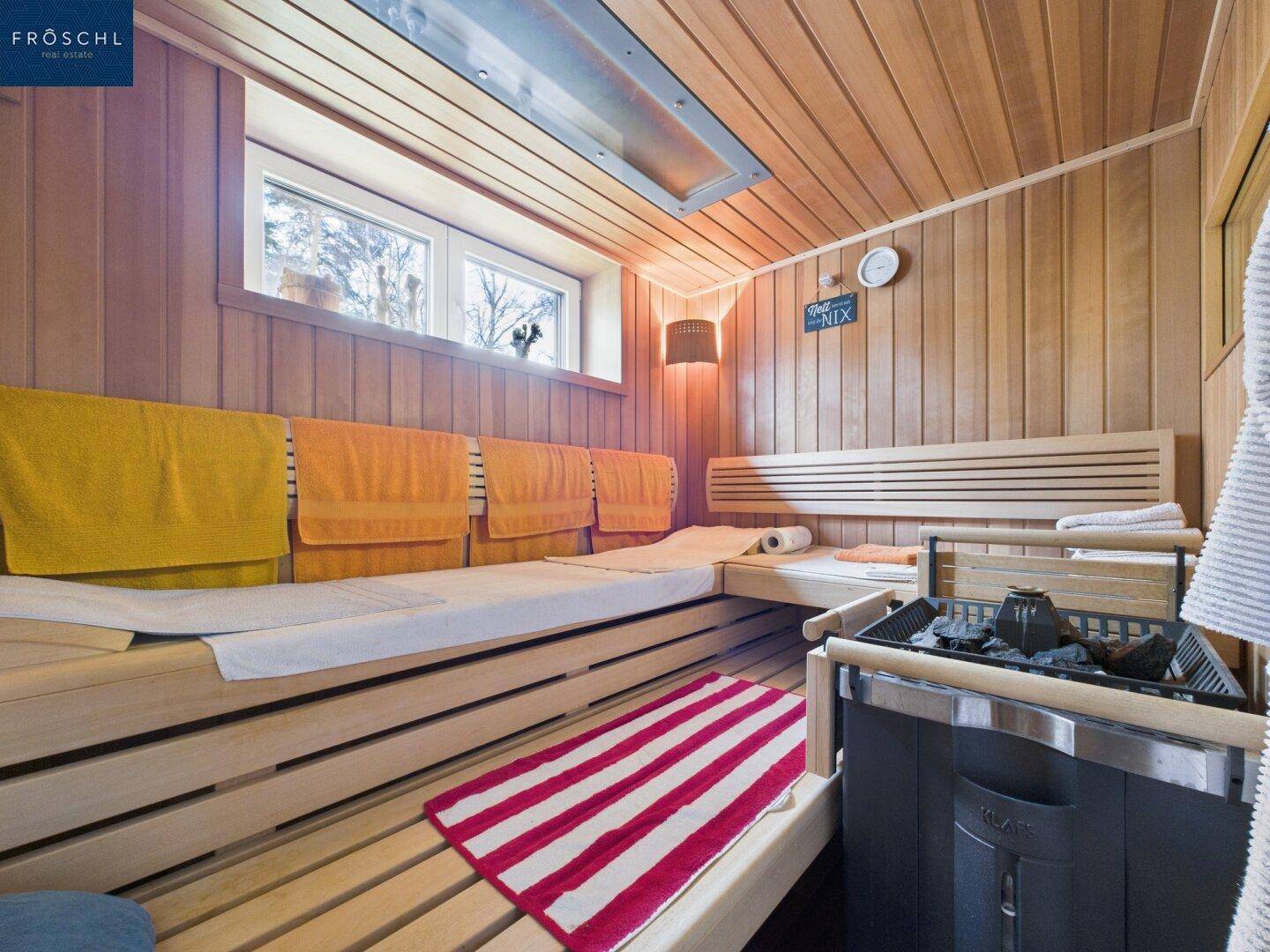 Gemütliche Holzsauna mit Bänken und Heizofen für entspannende Wellnessmomente.