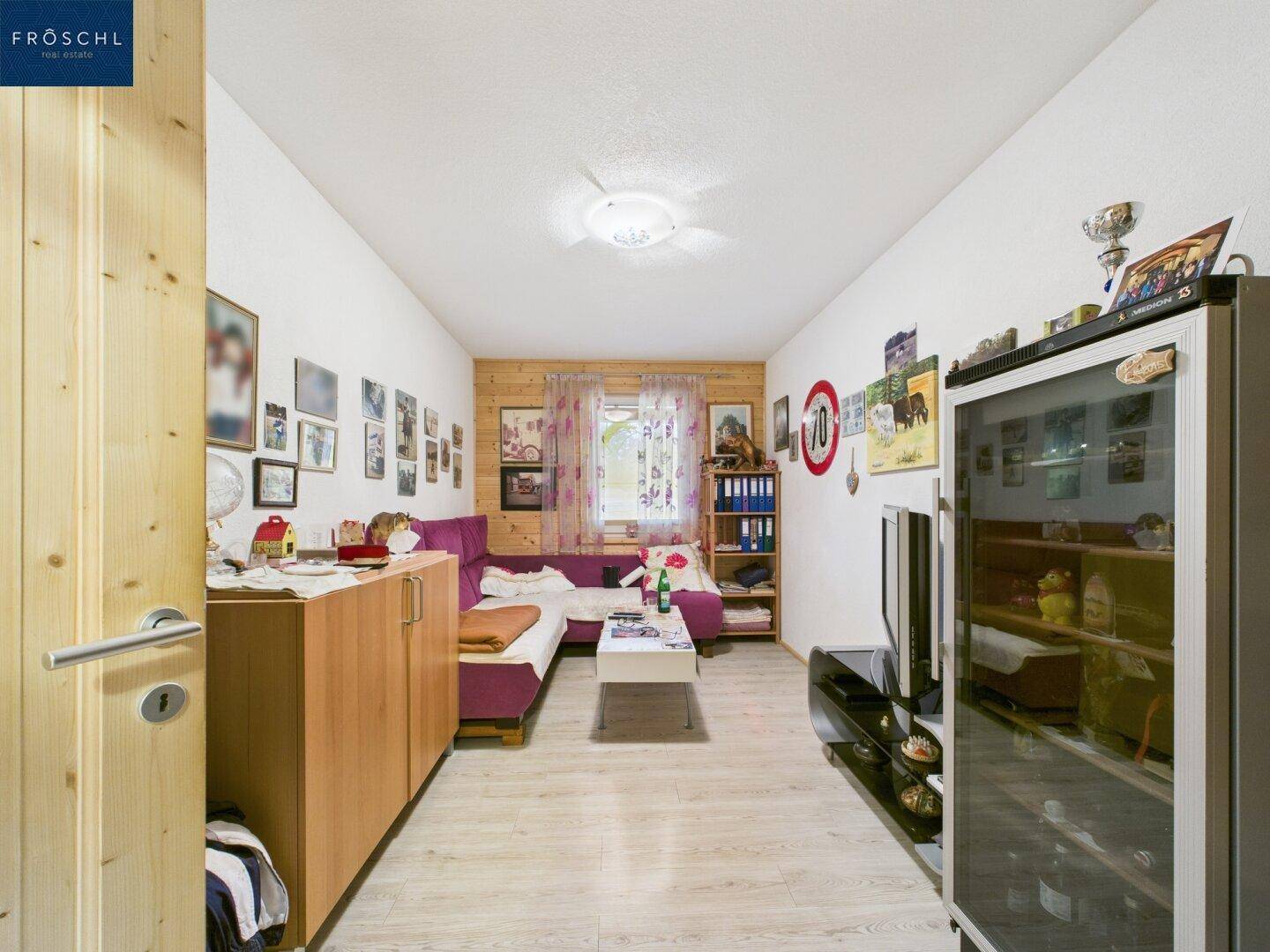 Gemütliches Wohnzimmer mit Holzwänden, Sofa und Fernseher, ideal zum Entspannen.