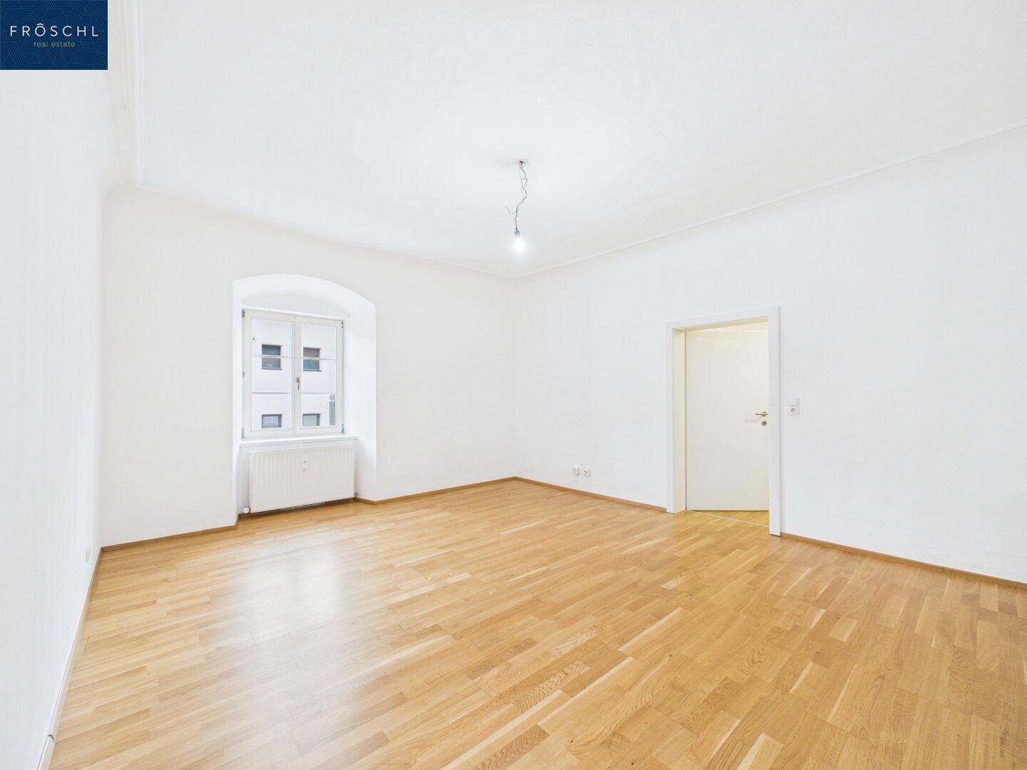Geräumiger, heller Raum mit Holzboden und Fenster, vielseitig nutzbar.