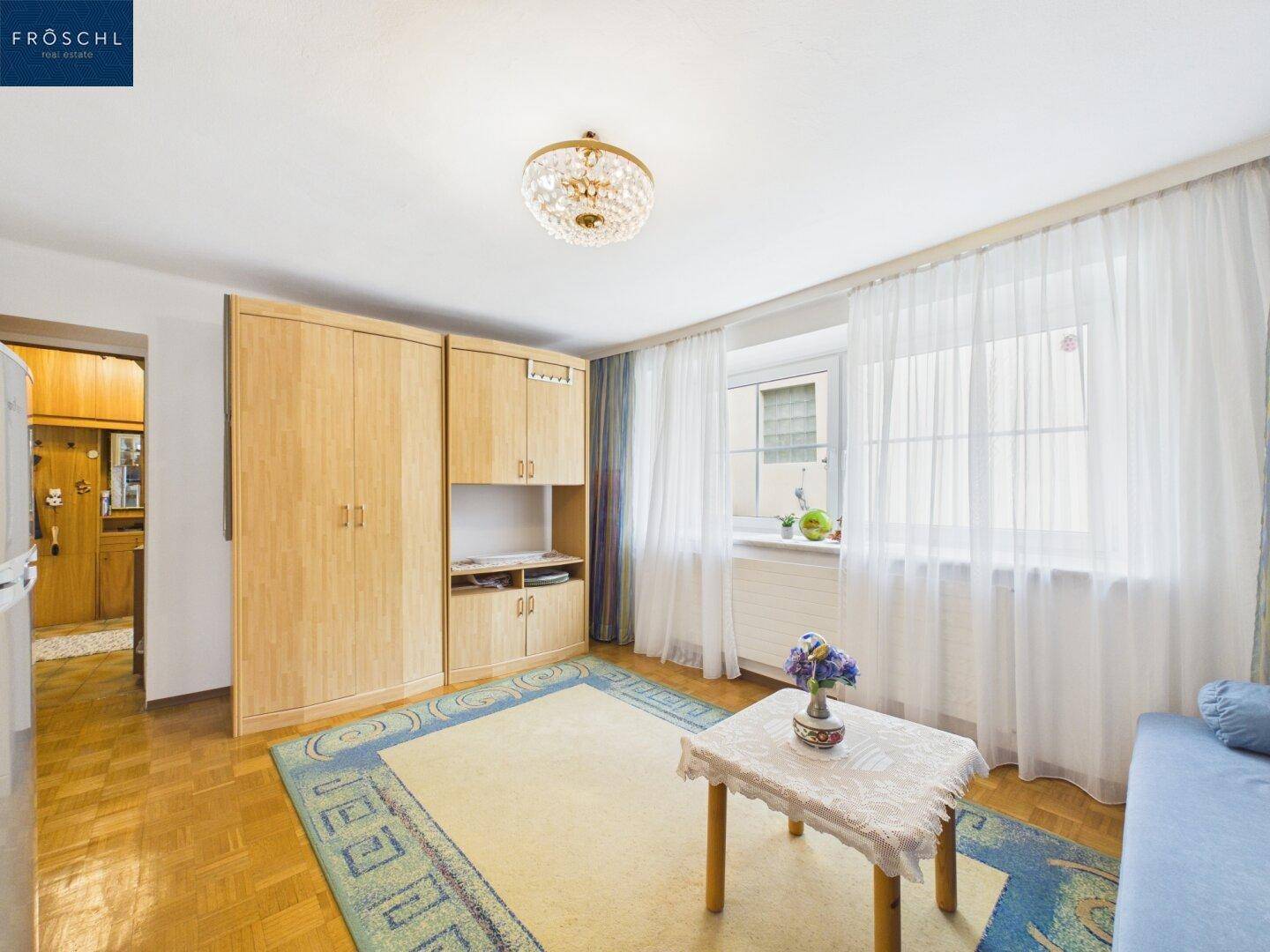Schlafzimmer mit Parkettboden, Einbauschränken und hellem Fensterbereich.