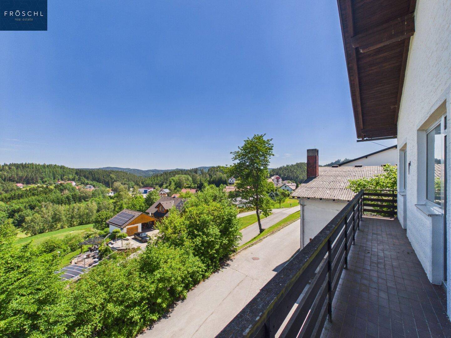 Langer Balkon mit Fliesenboden und Panoramablick auf die umliegende Natur.