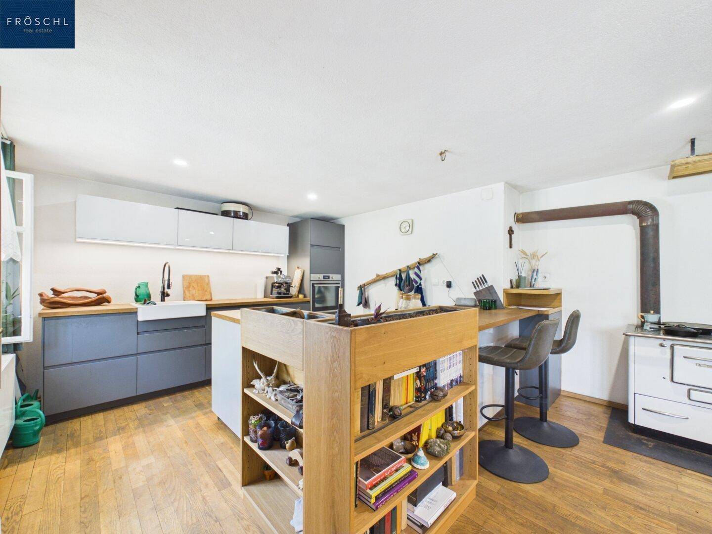 Moderne Küche mit Holztheke, integrierten Regalen und Holzboden in offenem Design.