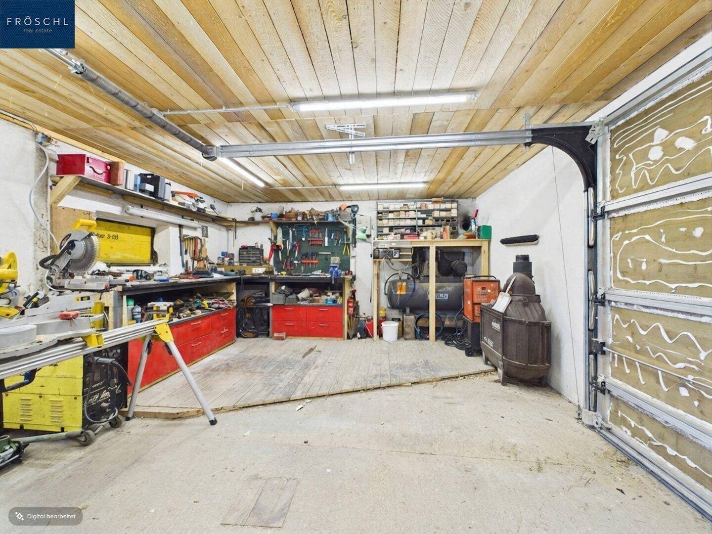 Geräumige Werkstatt mit vielen Werkzeugen, Arbeitsflächen und Holzdecke.