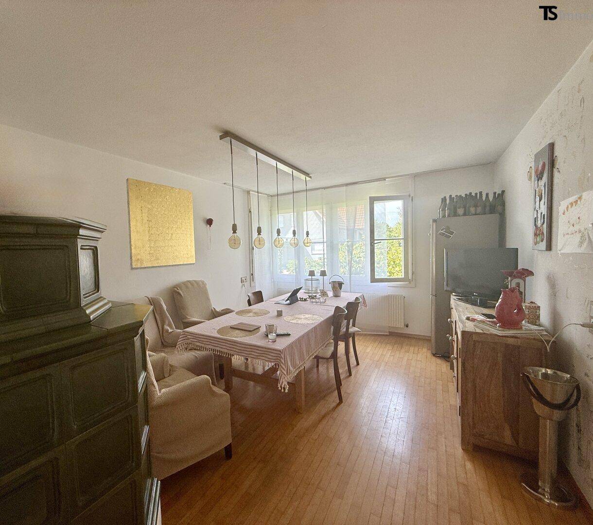 Esszimmer mit Holzboden, rustikalen Möbeln und viel Tageslicht.