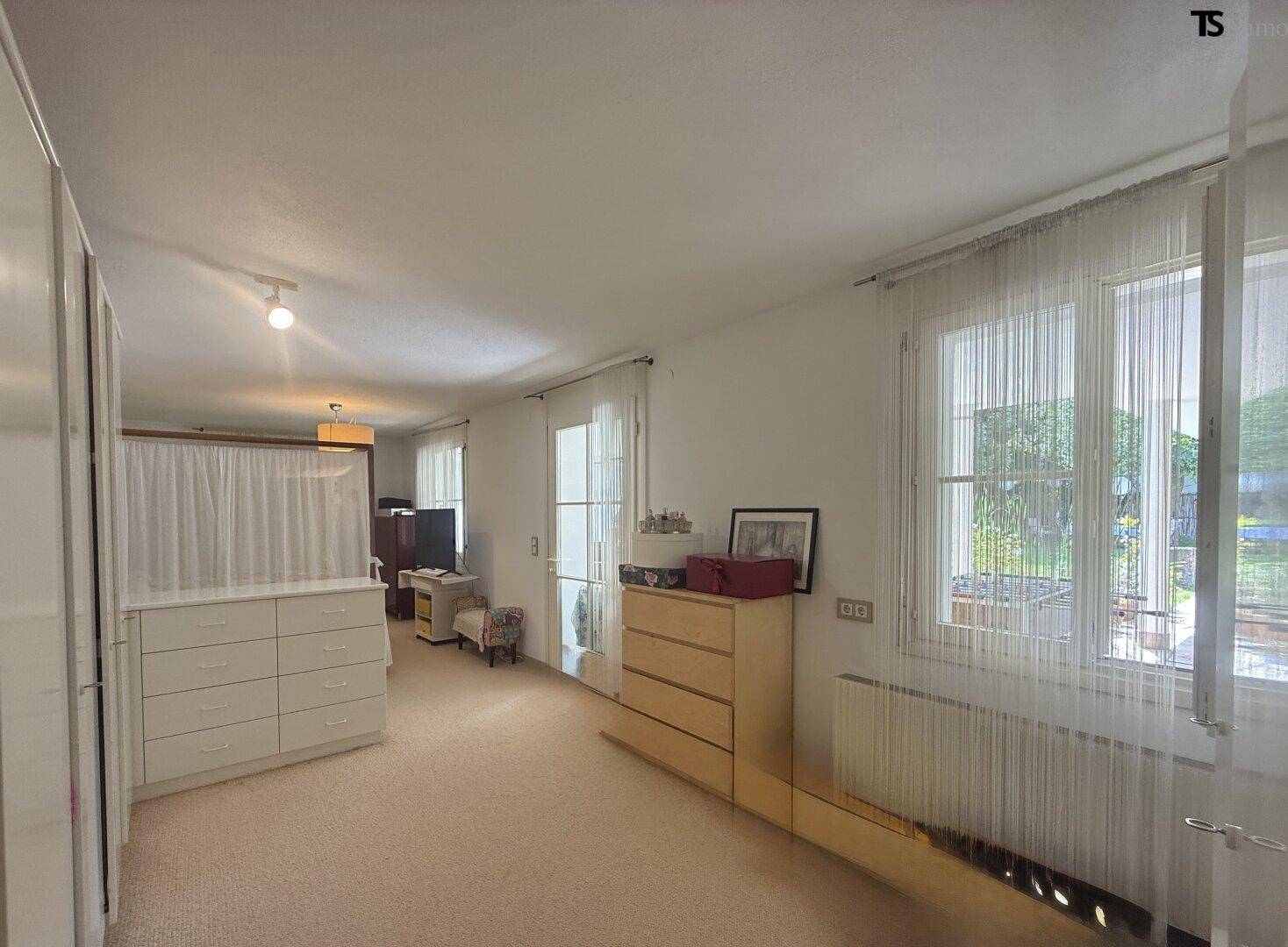 Helles Schlafzimmer mit Teppichboden und integrierten Kleiderschränken.