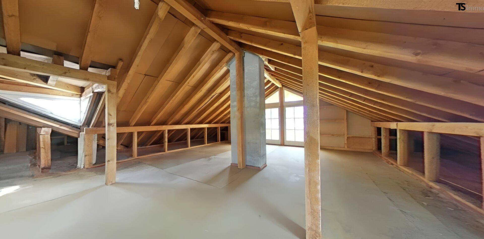 Geräumiger Dachboden mit Holzkonstruktion und Fenster für zukünftigen Ausbau.
