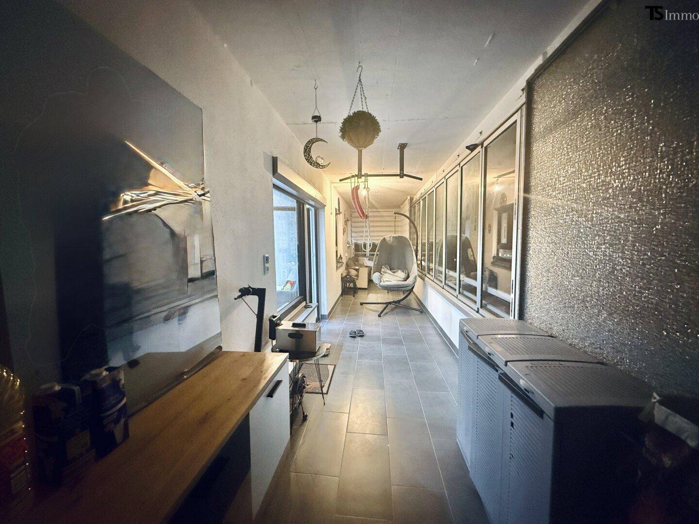 Lange verglaste Loggia mit Fliesenboden und viel Platz für individuelle Gestaltung.