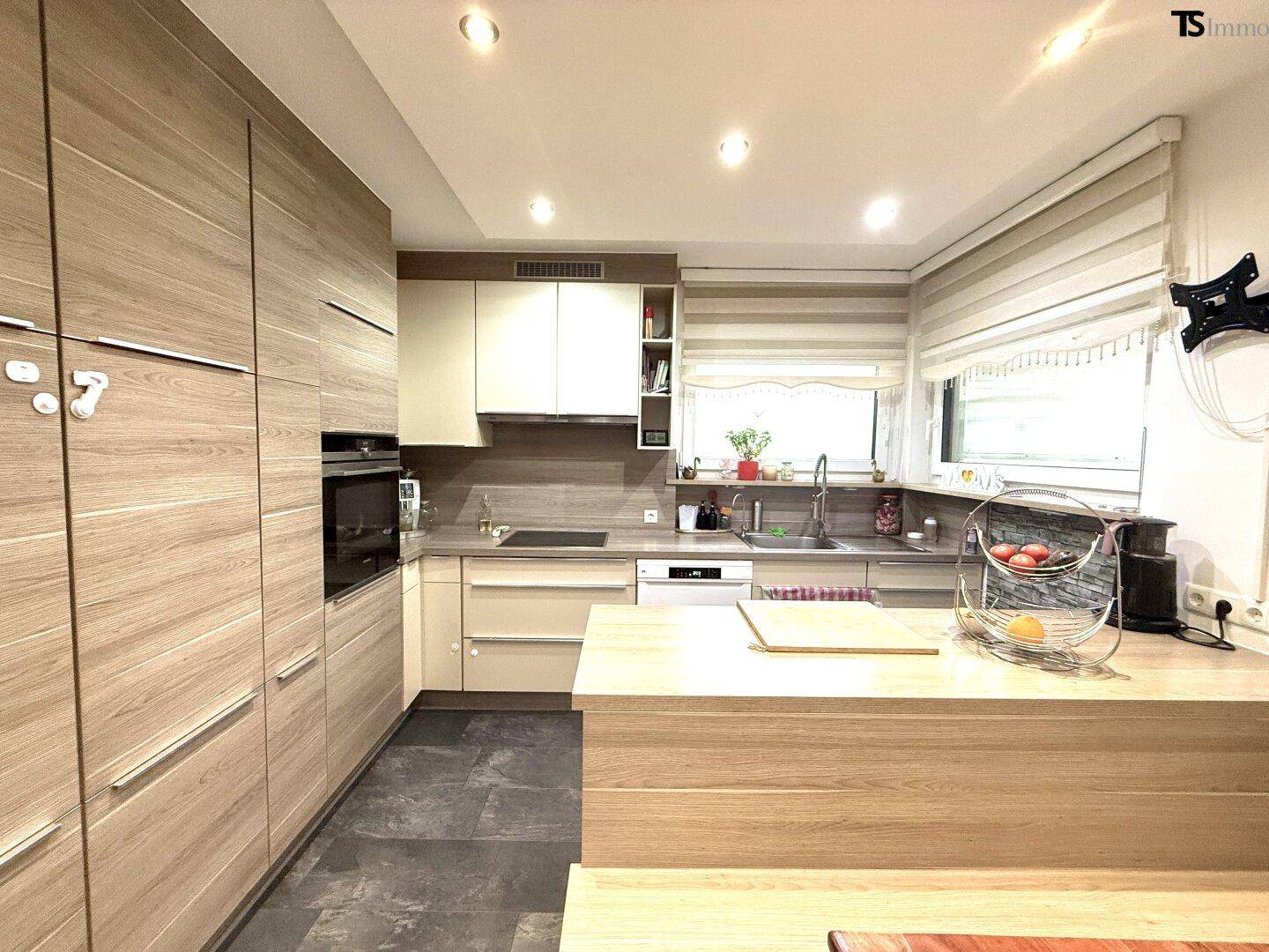 Moderne Einbauküche mit Holzfronten, integrierten Geräten und praktischer Kücheninsel.